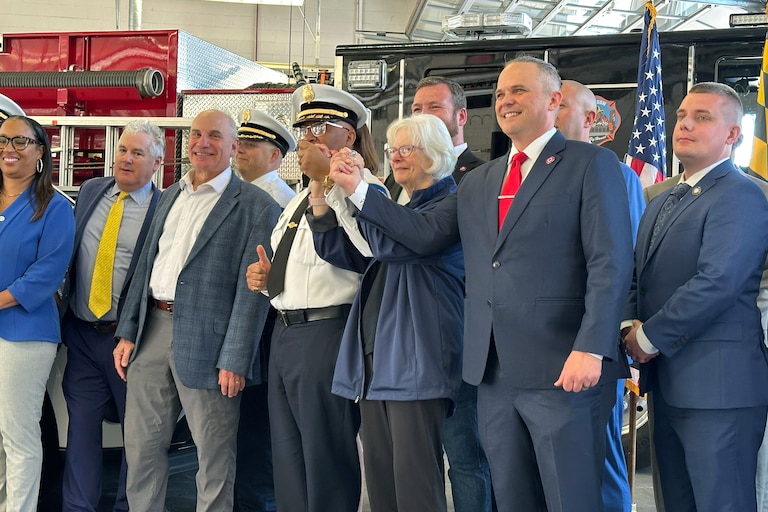 WEDNESDAY, APRIL 15, 2026 - Baltimore County Executive Kathy Klausmeier holds hands with Fire Chief Joseph Dixon (left) and president of the firefighters union Steve Redmer (right) after announcing funding to support the department’s staffing.