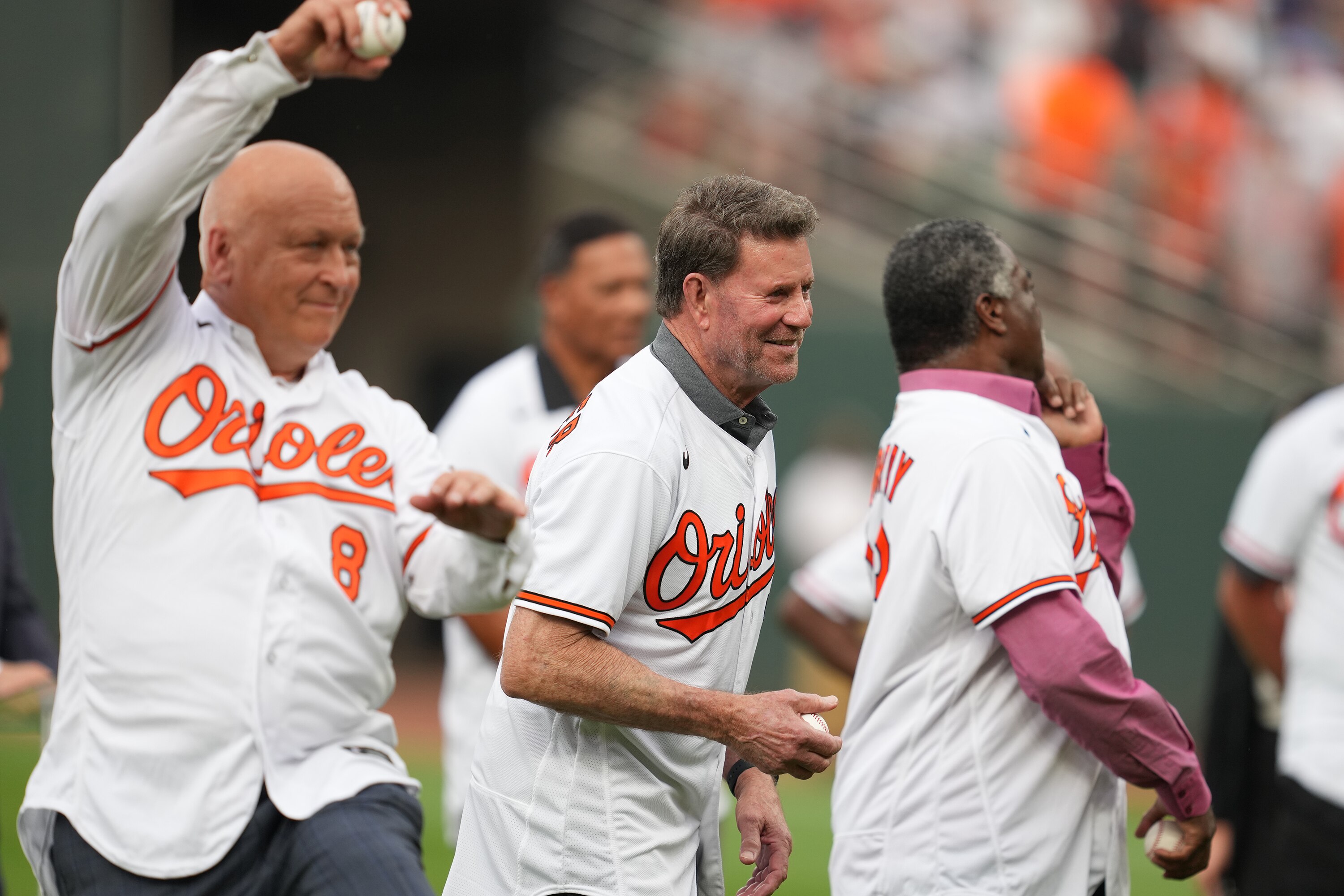 Former Orioles Cal Ripken Jr. (left), Jim Palmer (center) and Eddie Murray throw out first pitches as part of the 40th World Series reunion at Camden Yards last week.