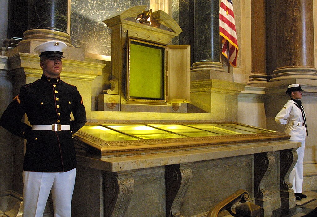 An honor guard stands next to the original copies of the Declaration of Independence, the Constitution and the Bill of Rights at the National Archives in Washington, D. C.