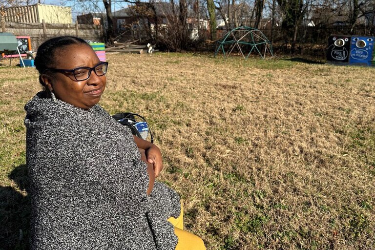 Tiffany Thompson sits on a bench amongst the remnants of a community lot where neighbors encouraged each other to reduce, reuse and recycle in Curtis Bay.
