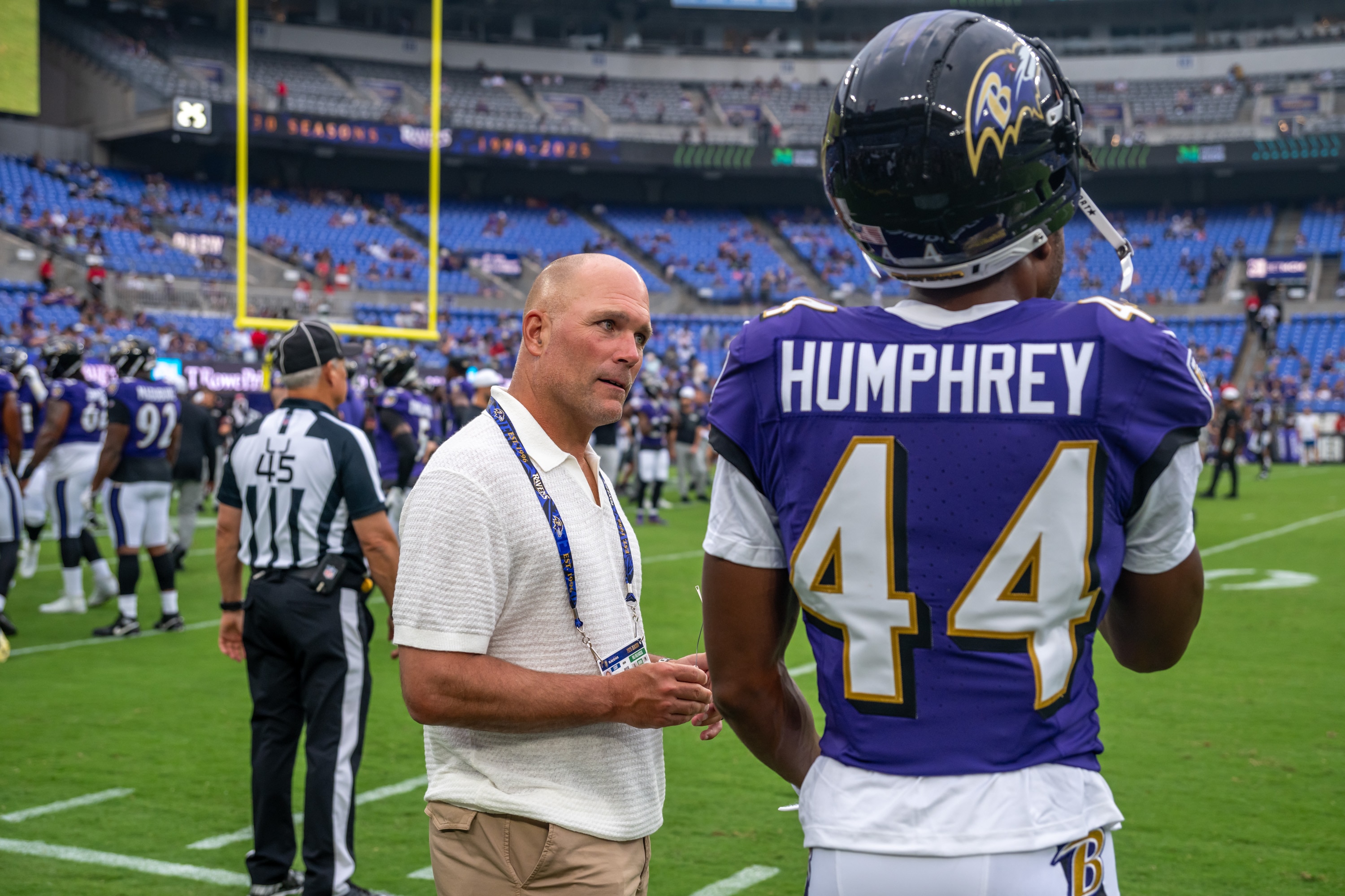 Ravens general manager Eric DeCosta talks with cornerback Marlon Humphrey prior to the preseason game against the Indianapolis Colts on Aug. 7.
