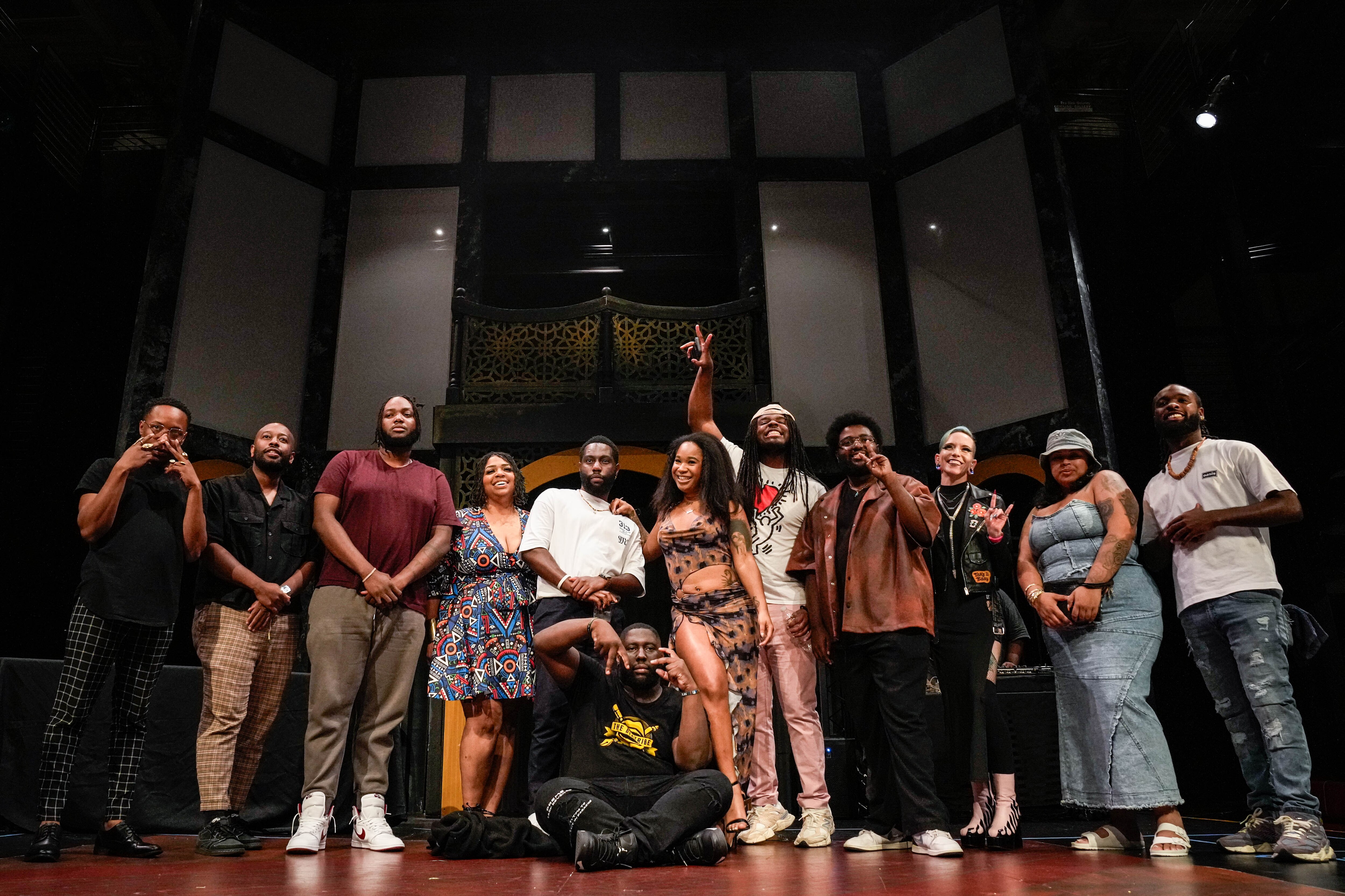 Black Chakra, center, sits on the stage with his fellow poets after being named the winner of the Charm City Slam Finals at the Chesapeake Shakespeare Company in Baltimore.