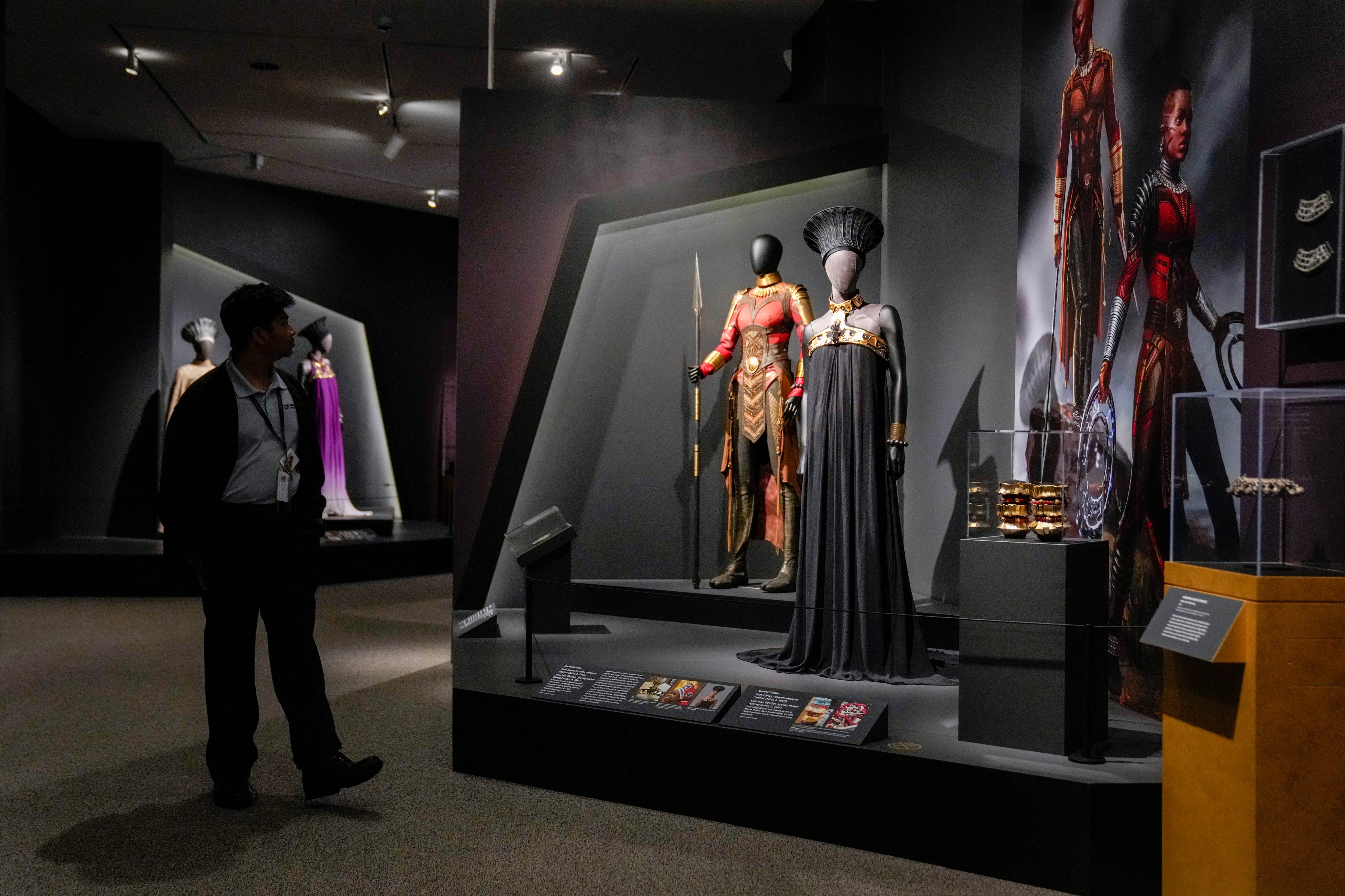 A museum employee examines the clothing and jewelry from Marvel’s “Black Panther” during a preview of the “Jewelry of the Afrofuture” exhibit at the Walters Art Museum in Baltimore.