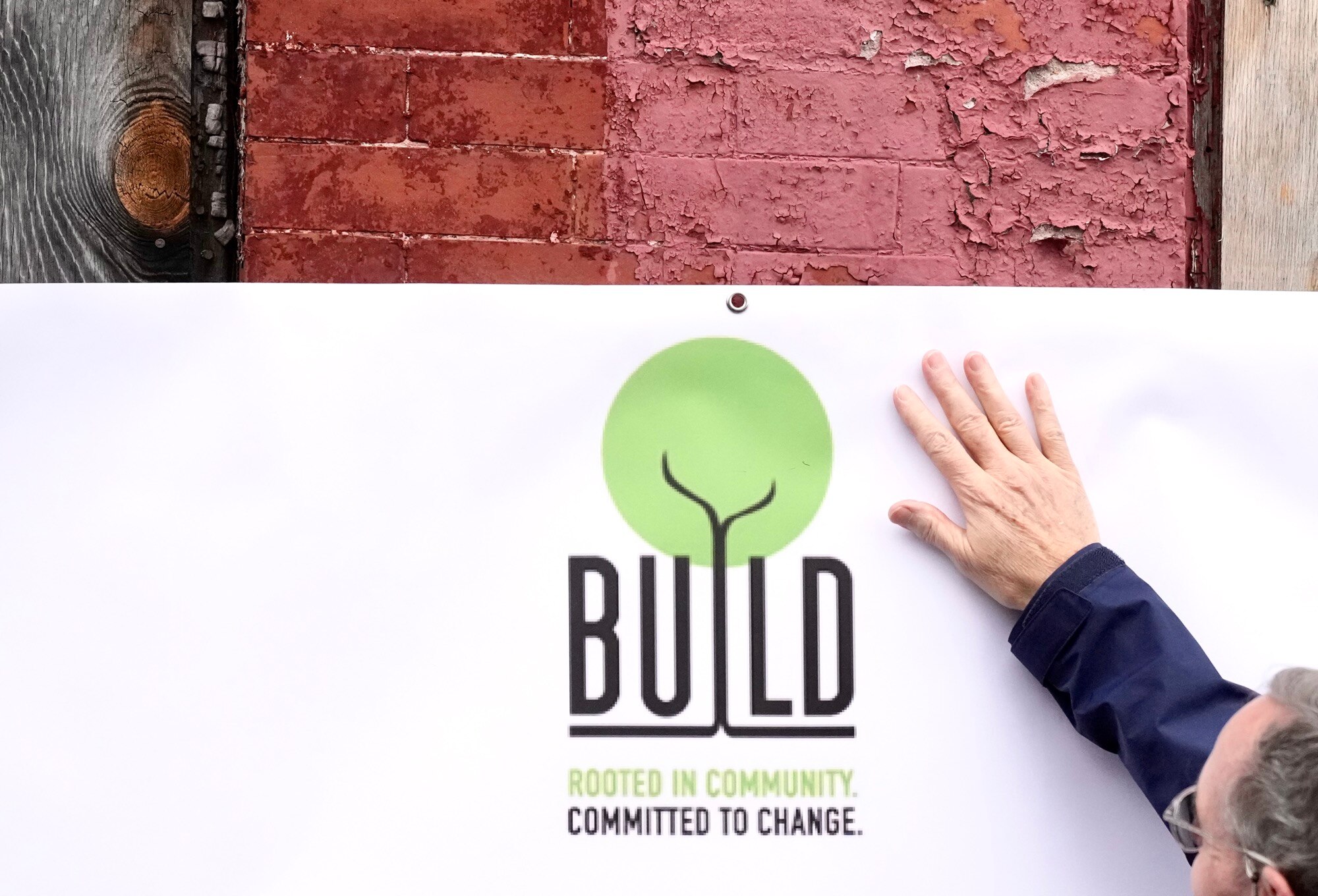 Mayor Brandon Scott speaks outside of vacant homes on West Saratoga Street during a press conference hosted by Build One Baltimore on Feb. 16, 2023.