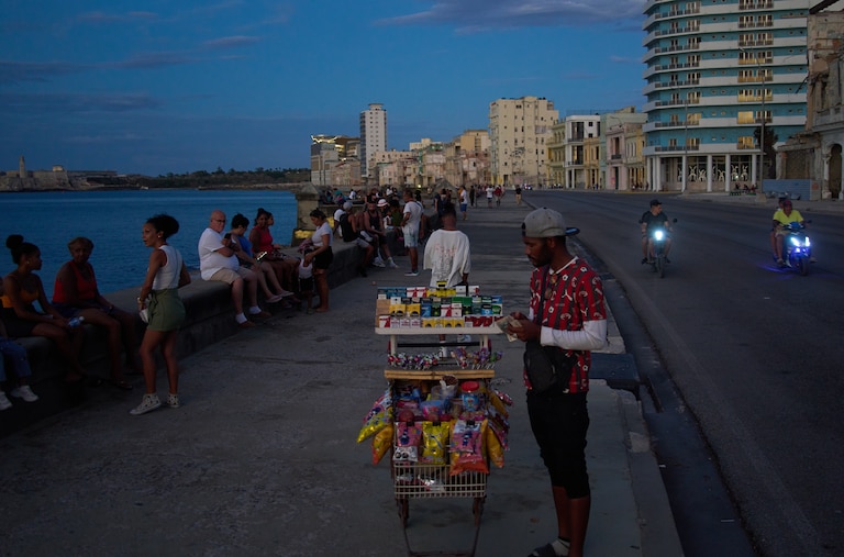 A street vendor waits for customers on the Malecón during a blackout in Havana, Monday, March 16, 2026.