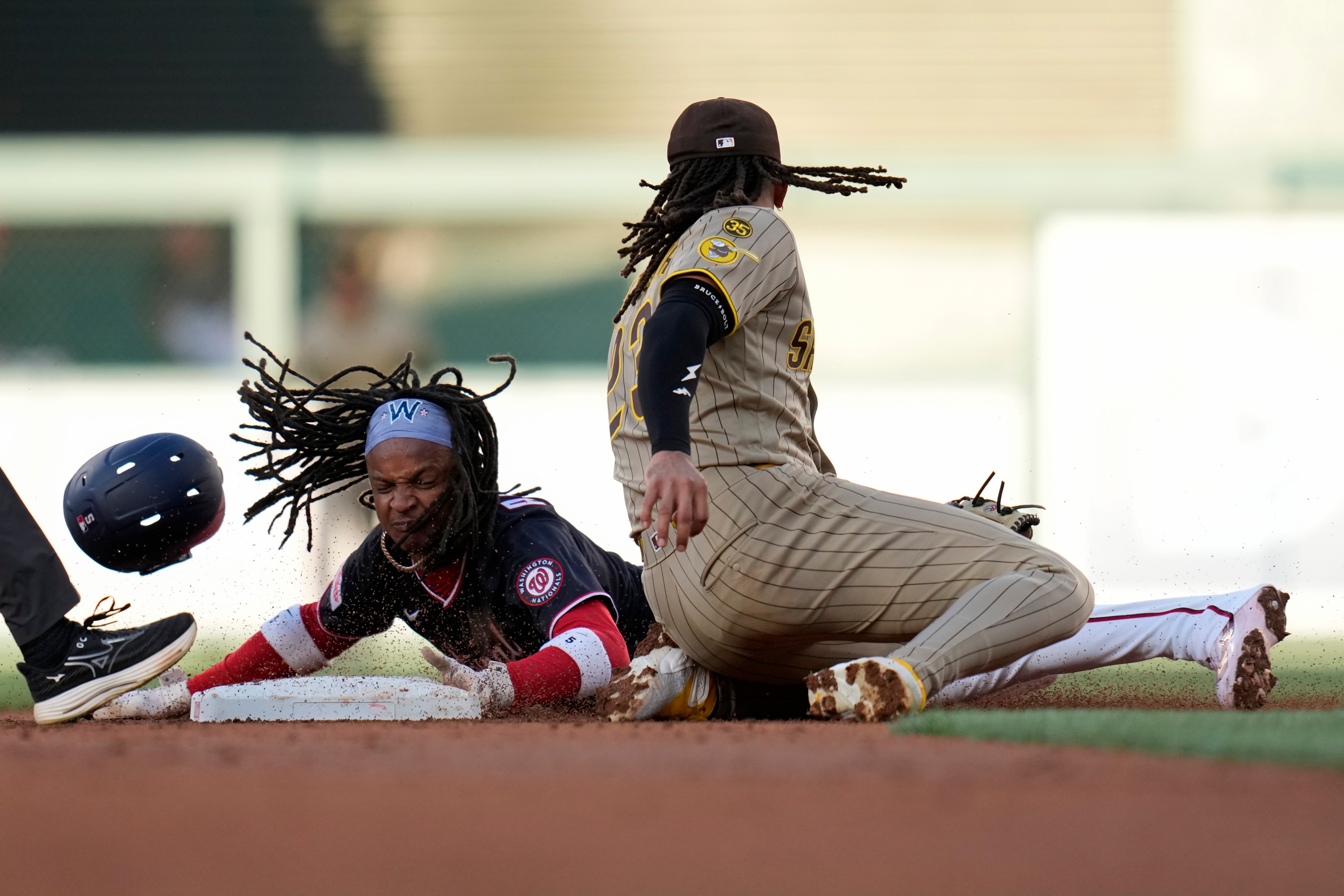 CJ Abrams of the Nationals beats the tag by Fernando Tatis Jr. of the Padres to steal a base in the first inning.