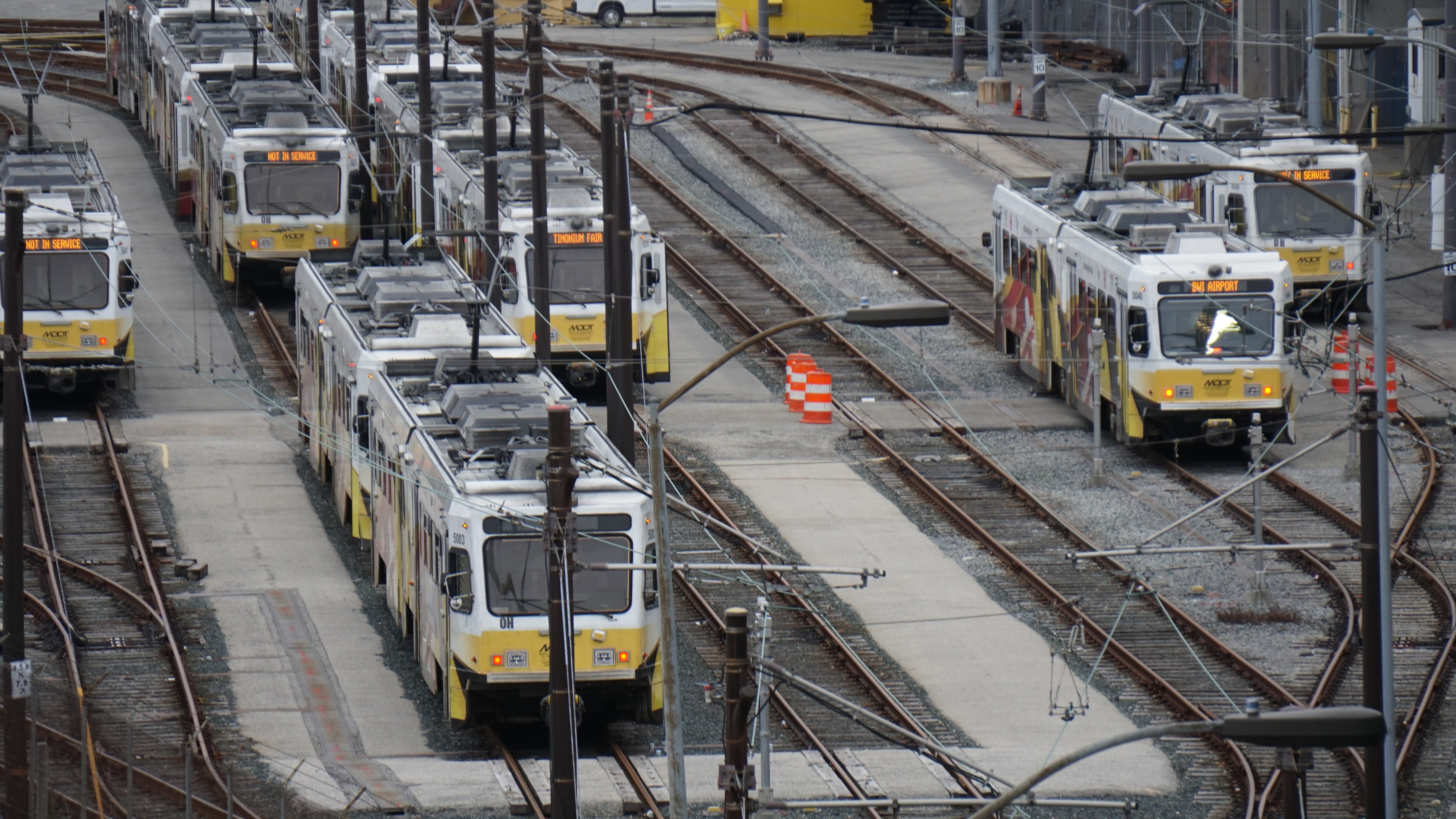 Six train cars idle on a lattice of train tracks.