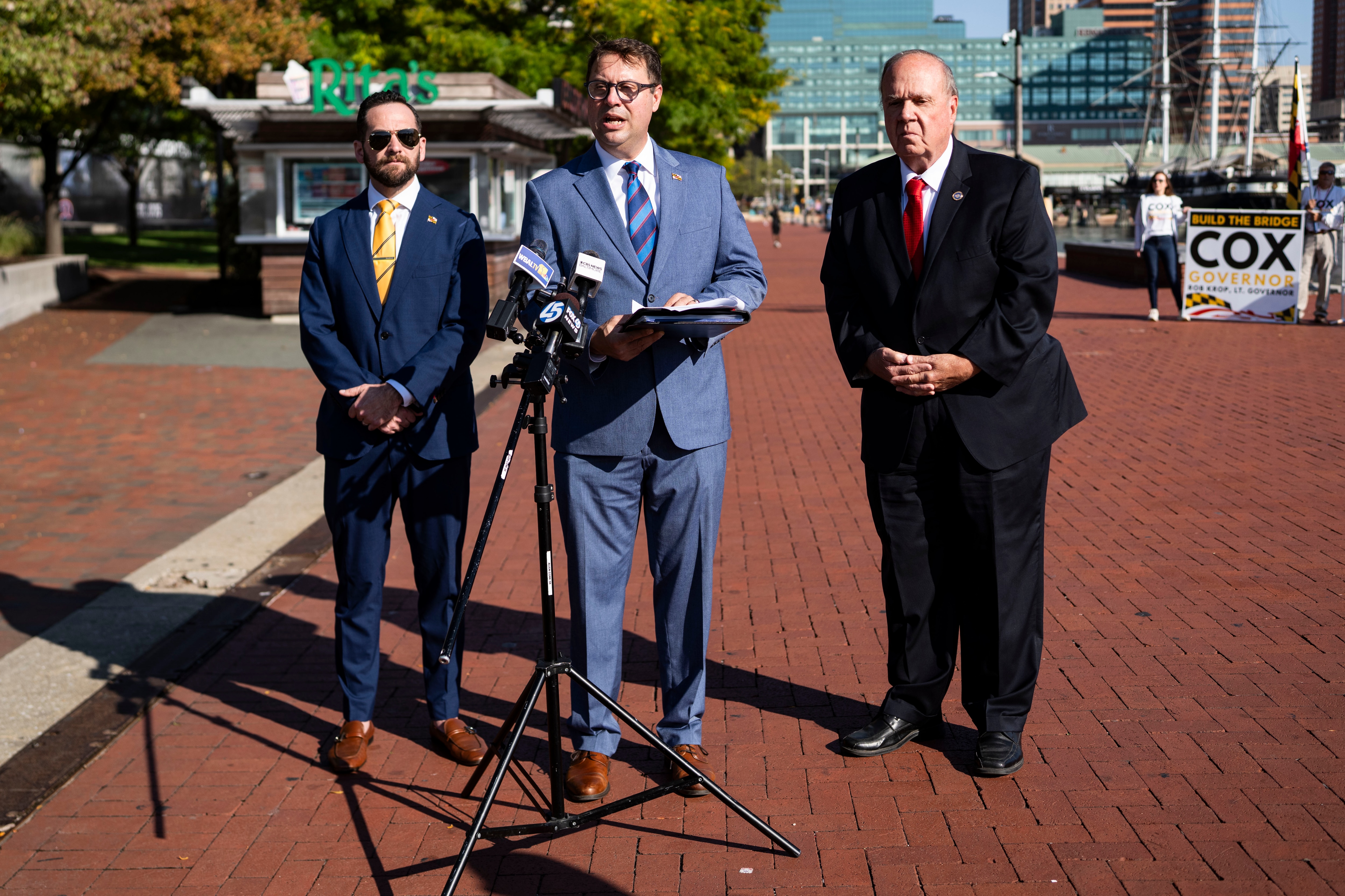 Republican gubernatorial candidate Dan Cox, center, holds a news conference, joined by his running mate, Rob Krop, left, and Del. Bob Long. Cox’s campaign messaging this election avoids mentioning President Donald Trump.