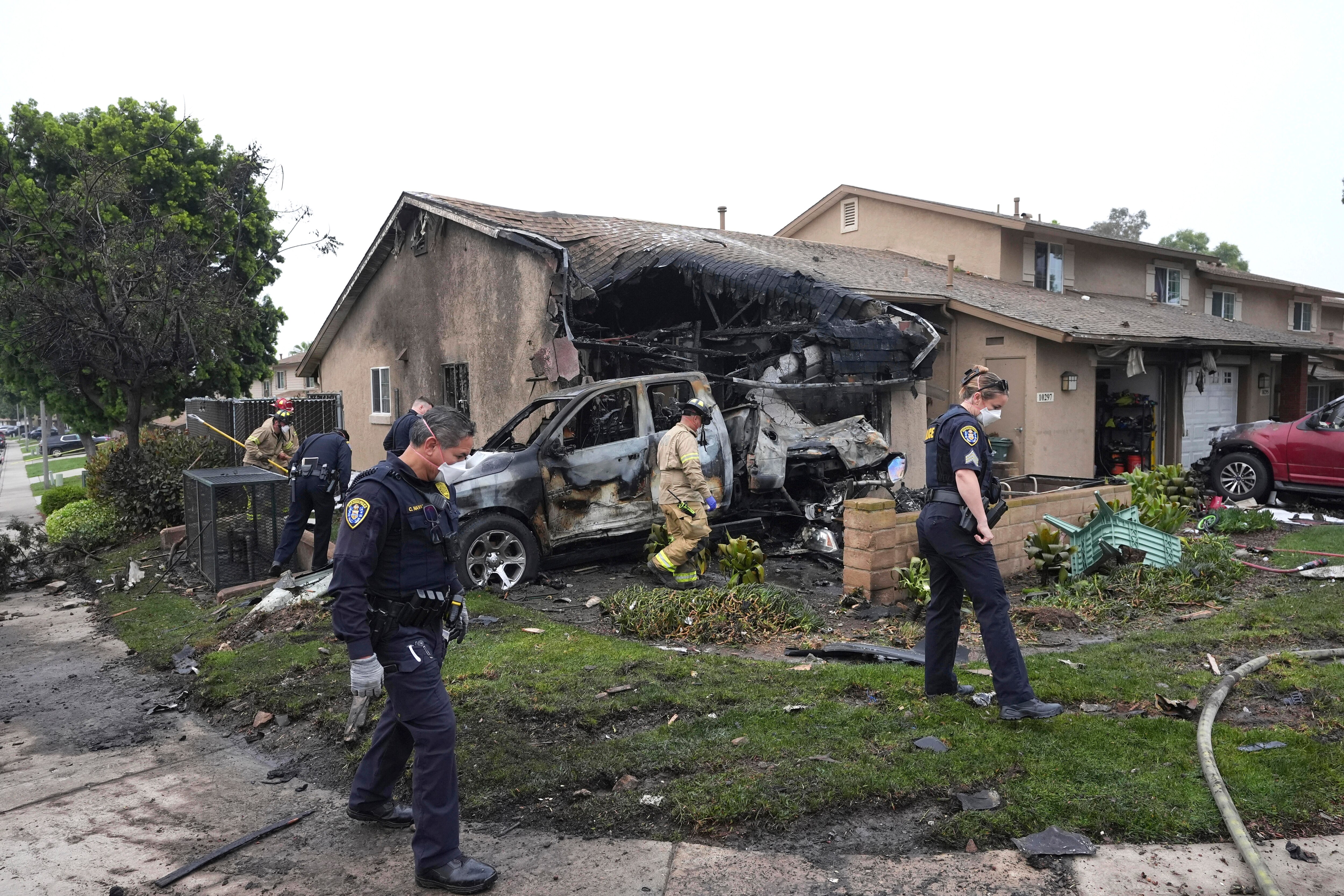 Authorities work the scene where a small plane crashed into a San Diego neighborhood, setting several homes on fire and forcing evacuations along several blocks early Thursday, May 22, 2025.