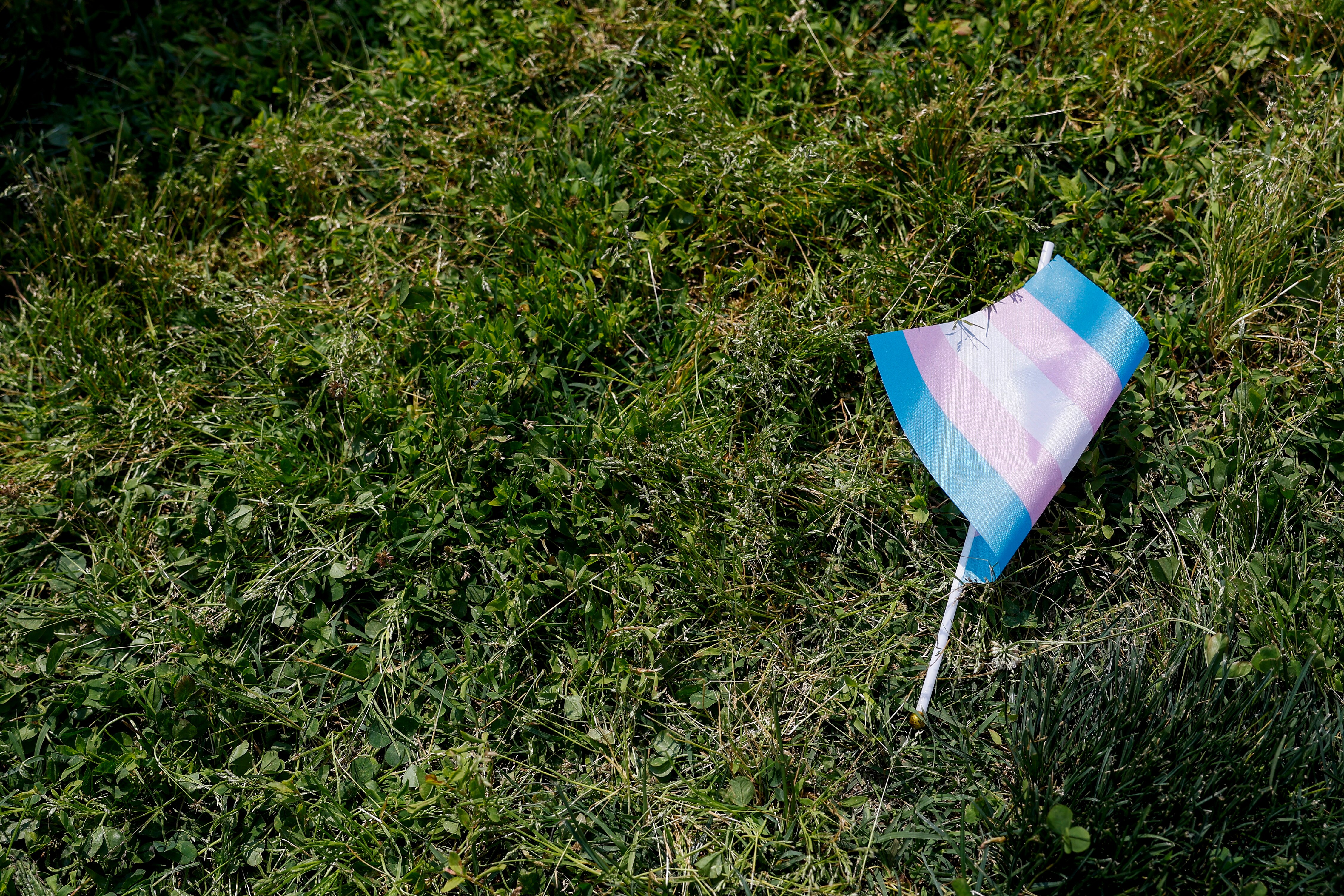 WASHINGTON, DC - MAY 22: A transgender flag sits on the grass during the "Trans Youth Prom" outside of the U.S. Capitol building on May 22, 2023 in Washington, DC. Trans and non-binary youth gathered to hold a Prom-like event that included music, dancing, and speeches. After the Prom, the kids and their families marched to the U.S. Supreme Court Building.