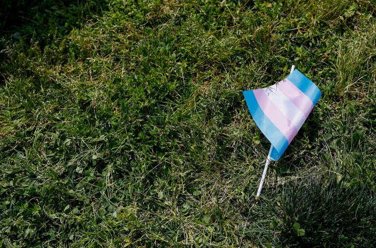 WASHINGTON, DC - MAY 22: A transgender flag sits on the grass during the "Trans Youth Prom" outside of the U.S. Capitol building on May 22, 2023 in Washington, DC. Trans and non-binary youth gathered to hold a Prom-like event that included music, dancing, and speeches. After the Prom, the kids and their families marched to the U.S. Supreme Court Building.