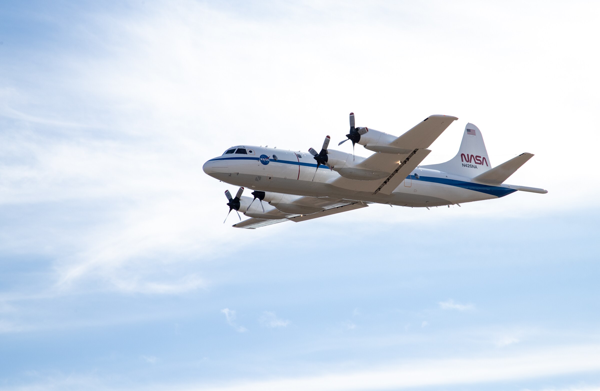 Nasa P-3 Orion returning to Wallops Flight Facility on 02/08/2024. The plane is large, with four propellers and a blue stripe.