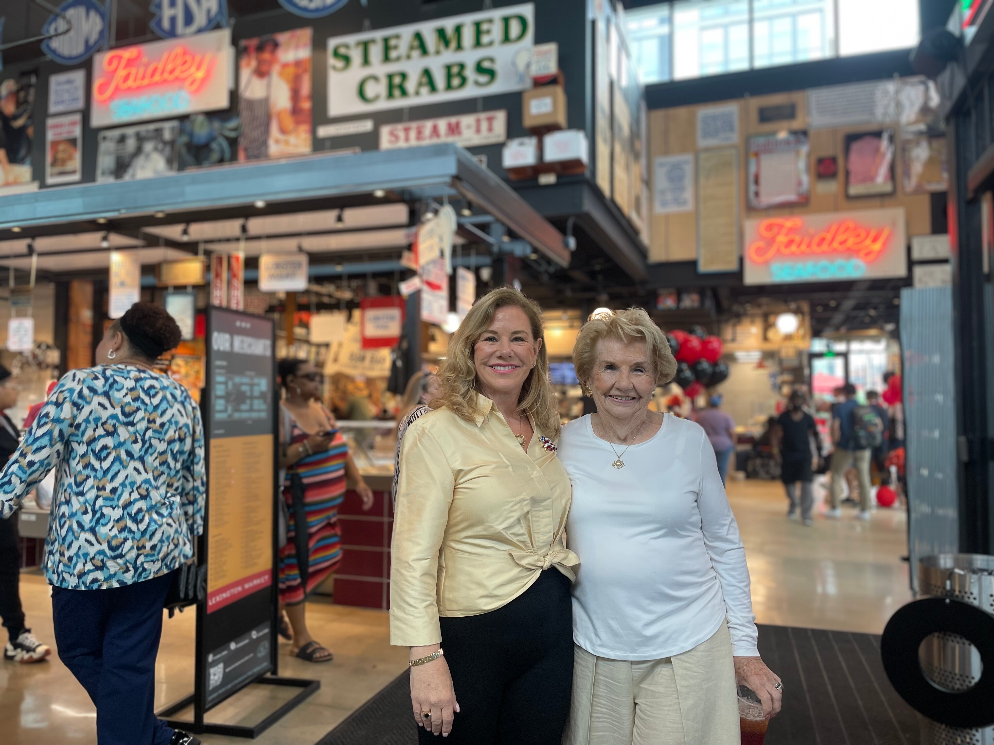 Damye Hahn, left, and Nancy Devine celebrate the grand opening of the Faidley's Seafood stall at the new Lexington Market.