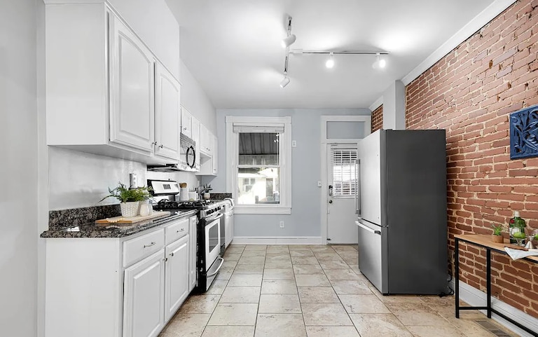 A kitchen with exposed brick wall on one side.