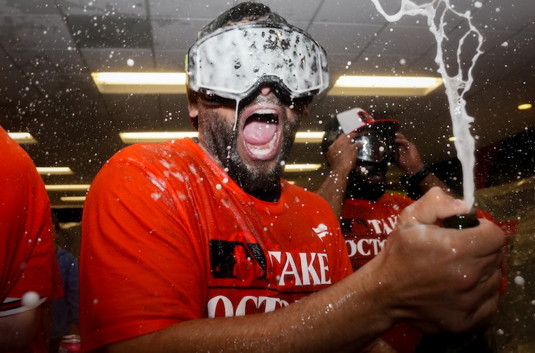 Baltimore Orioles taxi squad catcher José Godoy pops champagne in the clubhouse following the team’s playoff-clinching win against the Tampa Bay Rays on Sunday, September 17, 2023. The Orioles earned a spot in the playoffs for the first time since 2016.