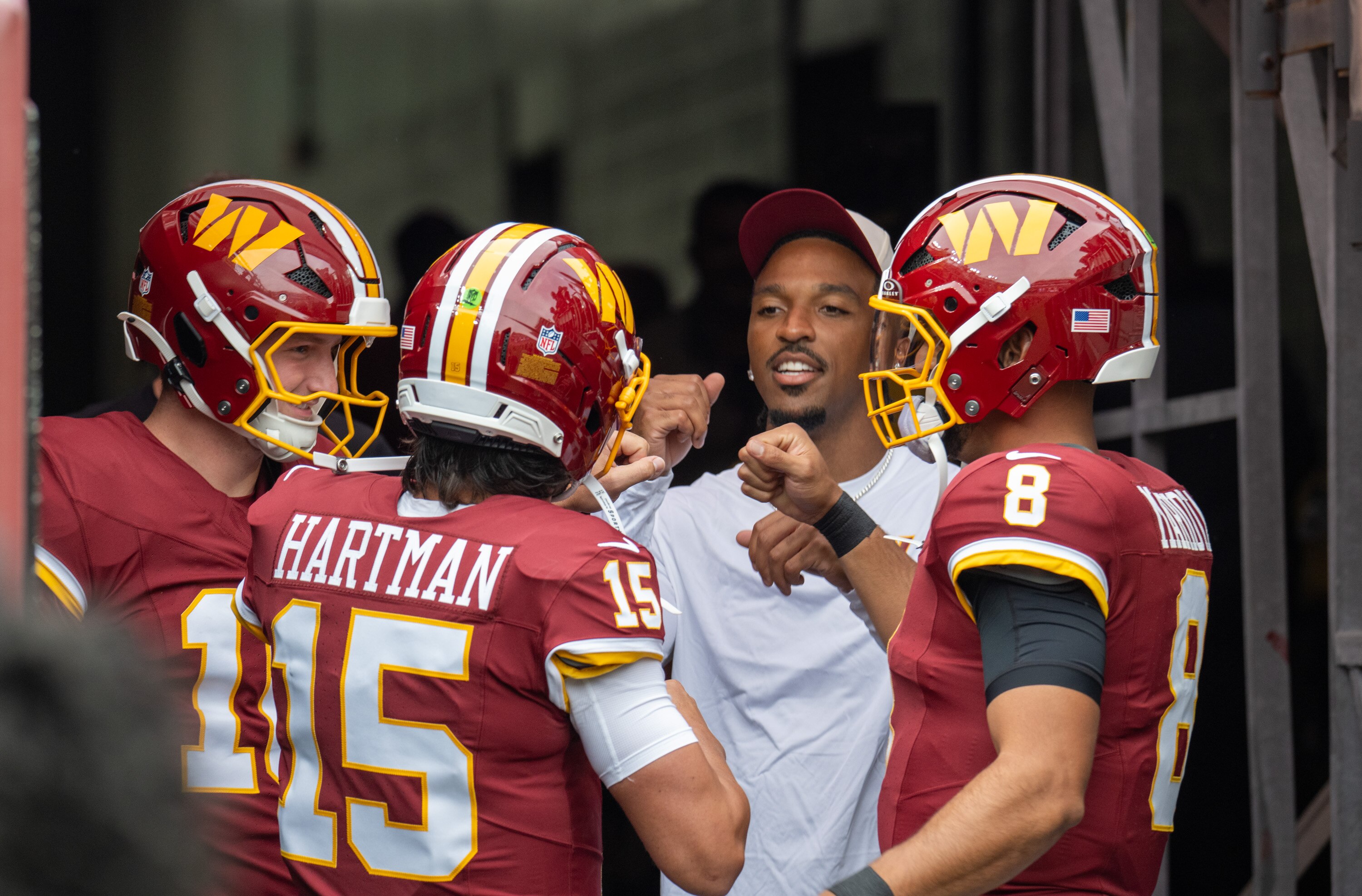 Commanders starter Jayden Daniels talks to the team’s other quarterbacks before the first preseason game against the Dolphins.