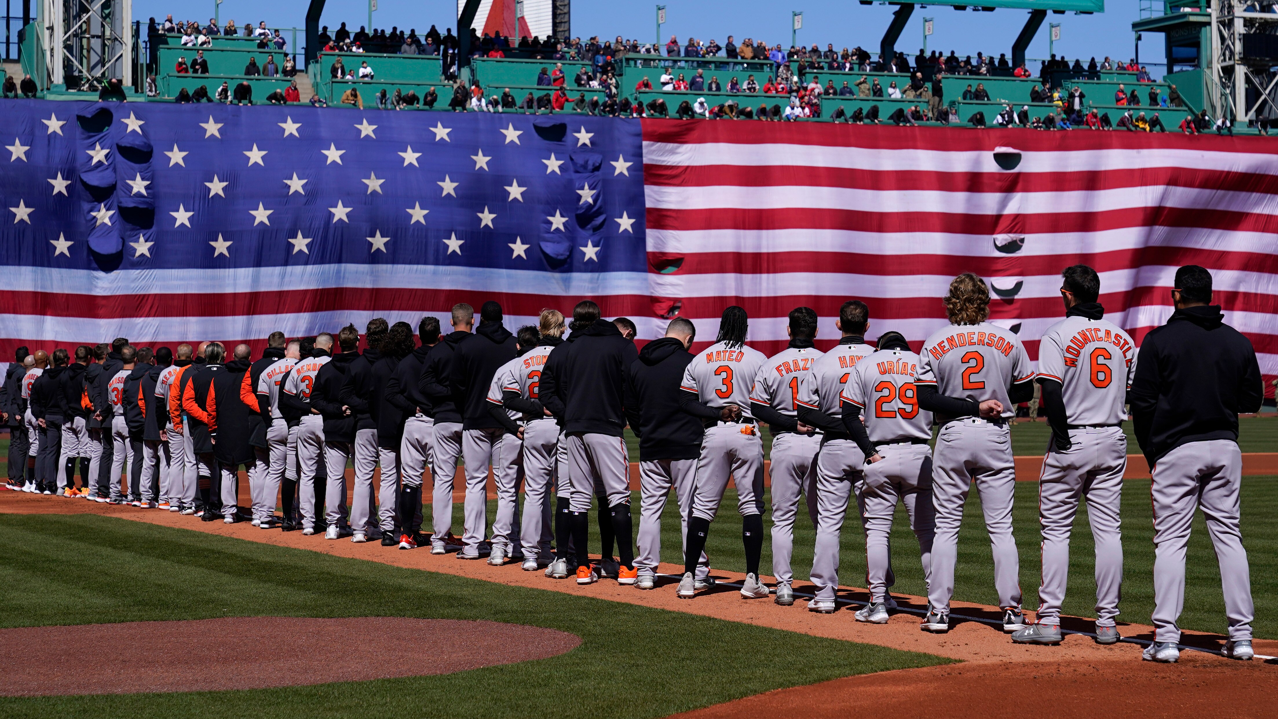 Baltimore Orioles players stand for the national anthem prior to the opening day baseball game against the Boston Red Sox, Thursday, March 30, 2023, in Boston.