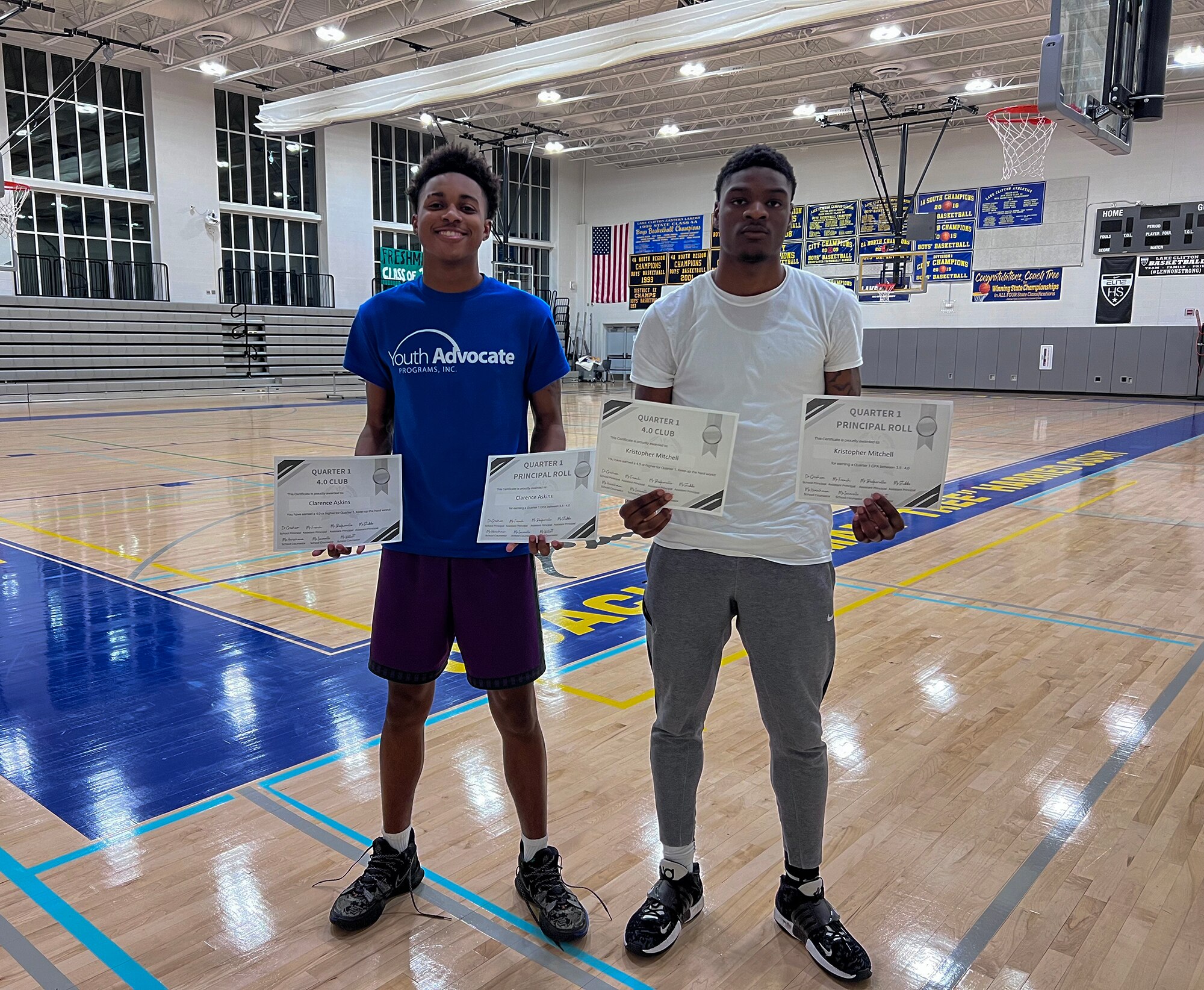 Clarence “Ray” Askins (left), 17, and Kristopher Mitchell (right), 17, show off their 4.0 GPA certificates in the gym of the REACH! Partnership school.