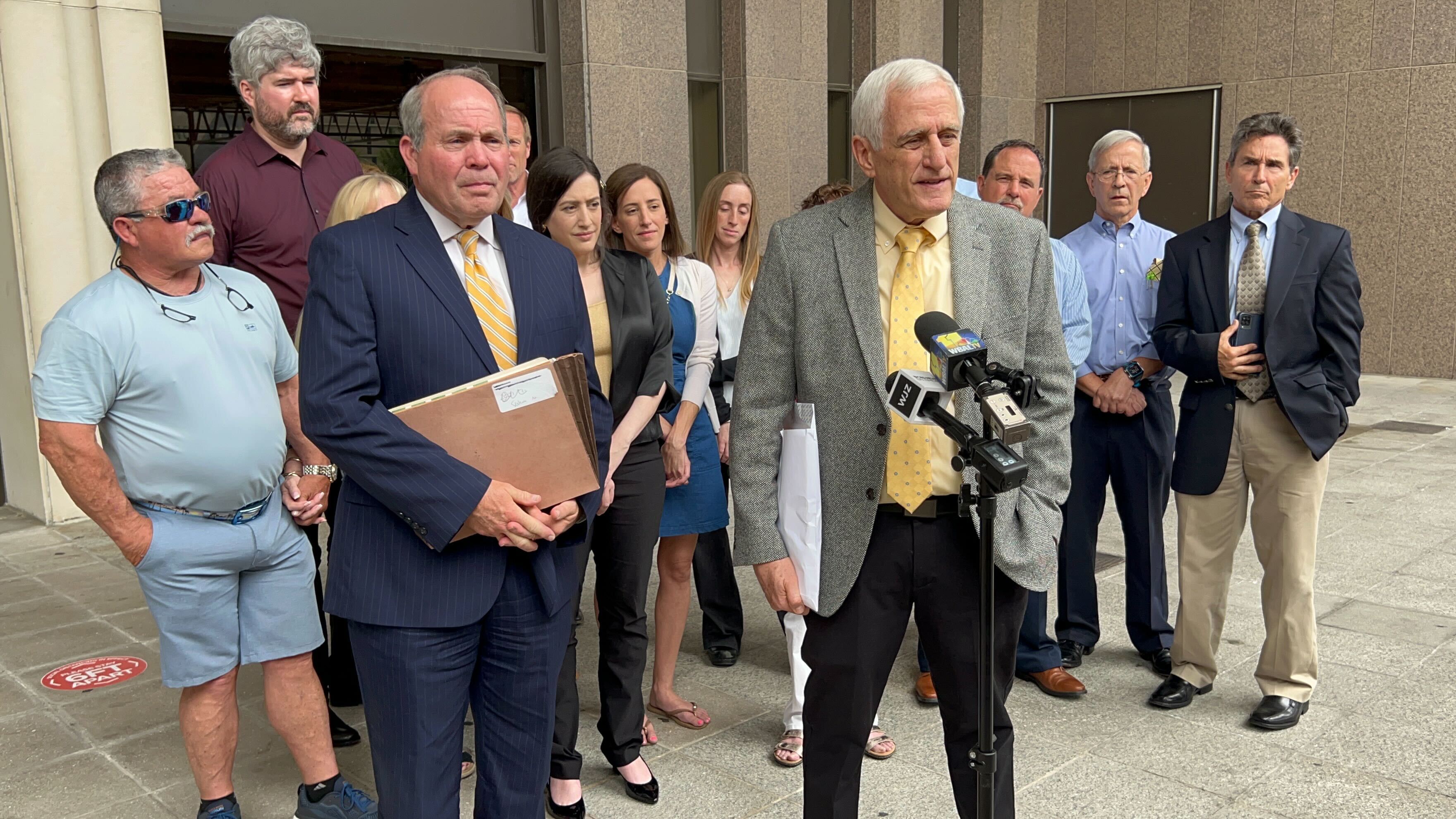Neil Adleberg, 75, of Reisterstown, center, speaks to reporters on Friday after Baltimore County Circuit Judge Dennis M. Robinson Jr. found him not guilty of sexual abuse of a minor, sexual solicitation of a minor, second-degree rape and attempted second-degree rape. His attorney, Joe Murtha, left, looks on.