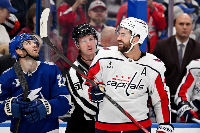 Washington Capitals right wing Tom Wilson (43) laughs as linesman Dylan Blujus (57) separates him from the Tampa Bay Lightning bench area during the second period of an NHL hockey game Saturday, Oct. 3, 2026, in Tampa, Fla. (AP Photo/Jason Behnken)