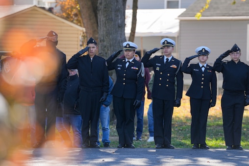 Attendees salute during the Pledge of Allegiance at Veterans Memorial Park, just outside of Wells-McComas VFW Post 2678, during a Veterans Day observance ceremony in Sparrows Point, Md., on Tuesday, November 11, 2025.