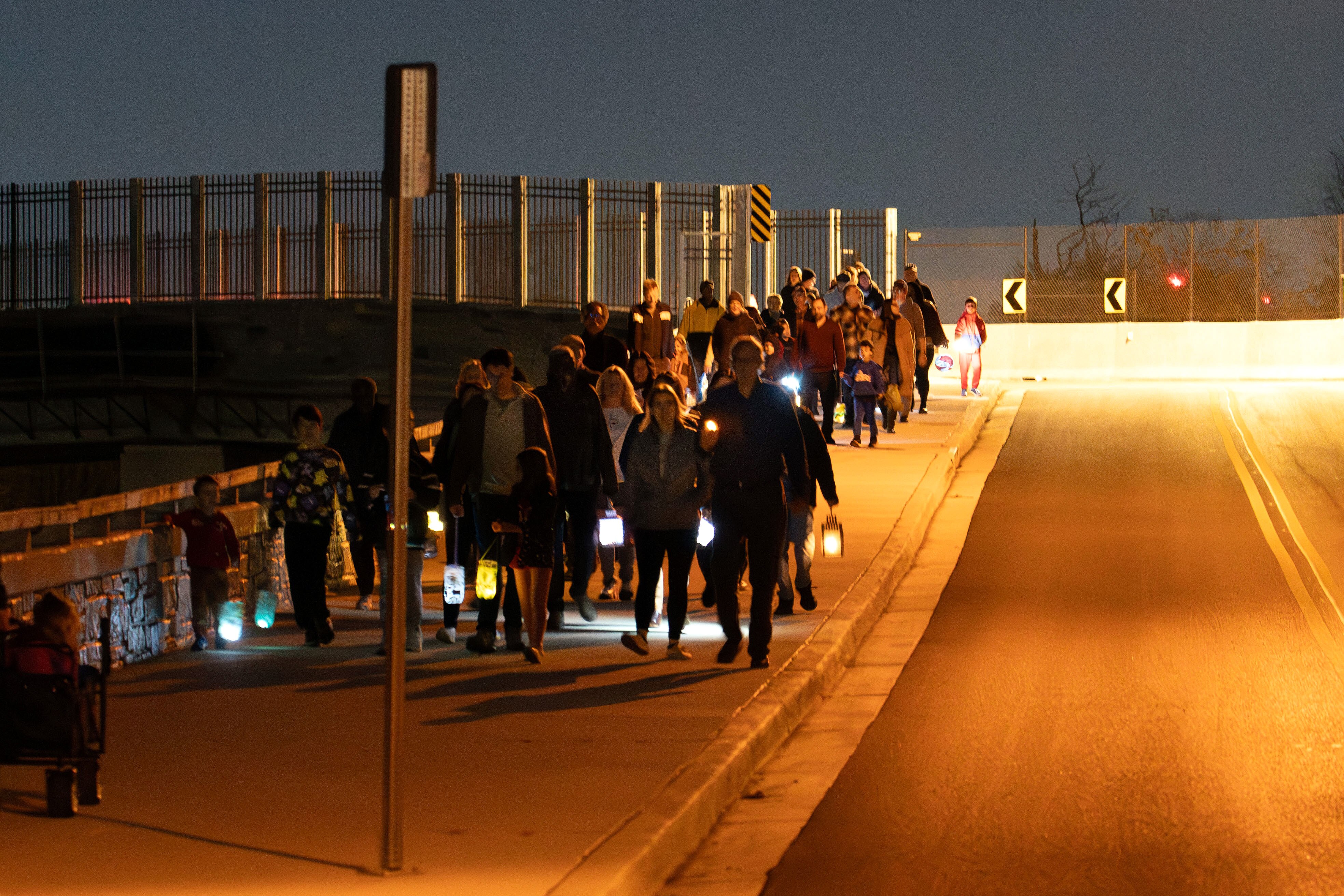 Community members participate in a lantern walk across Talbot Avenue Bridge in Silver Spring to acknowledge the history of segregation between the Lyttonsville and North Woodside neighborhoods.