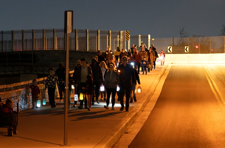Community members participate in a lantern walk across Talbot Avenue Bridge in Silver Spring to acknowledge the history of segregation between the Lyttonsville and North Woodside neighborhoods.