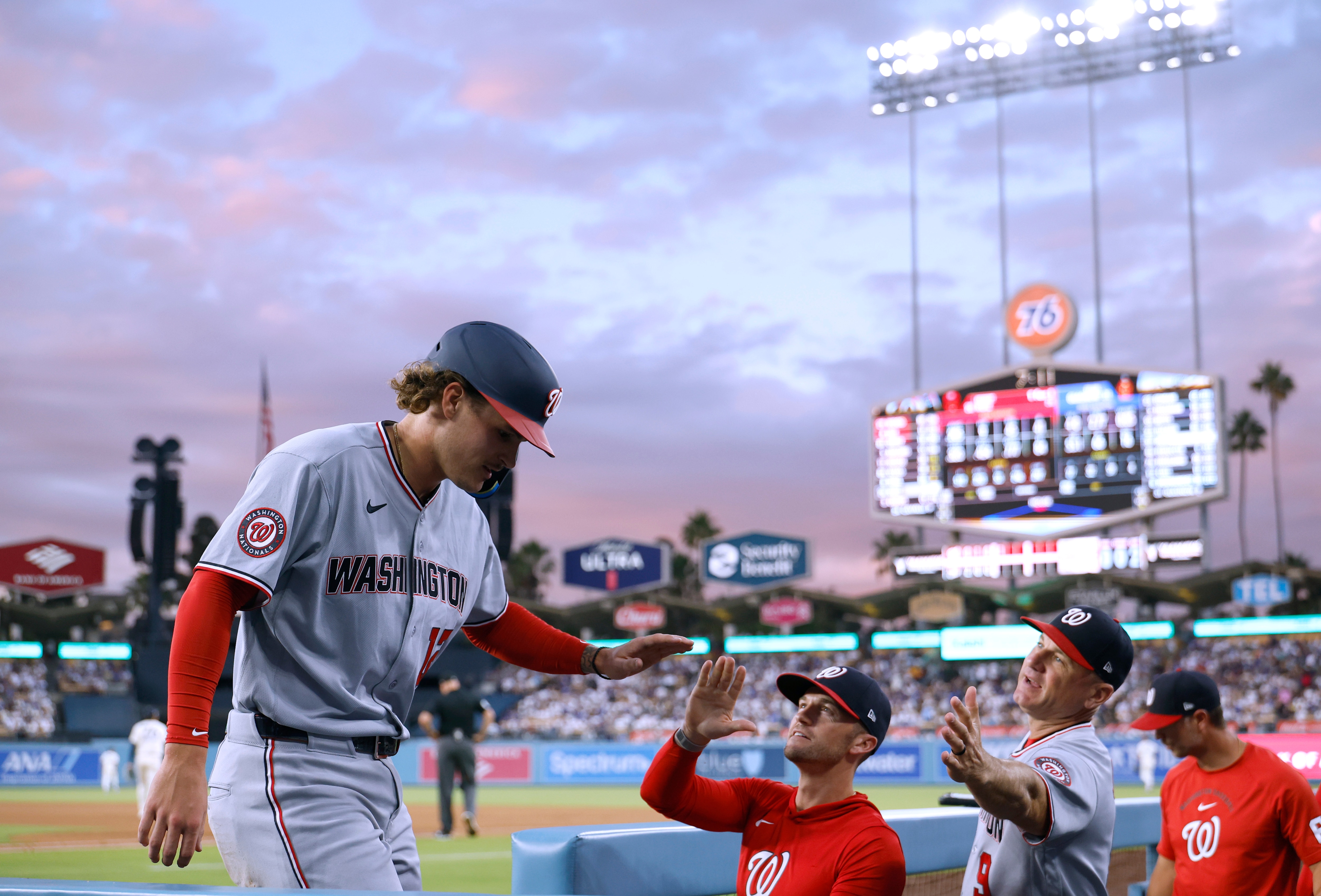 Brady House high-fives manager Blake Butera after scoring a run in the fourth inning Saturday night in Los Angeles.