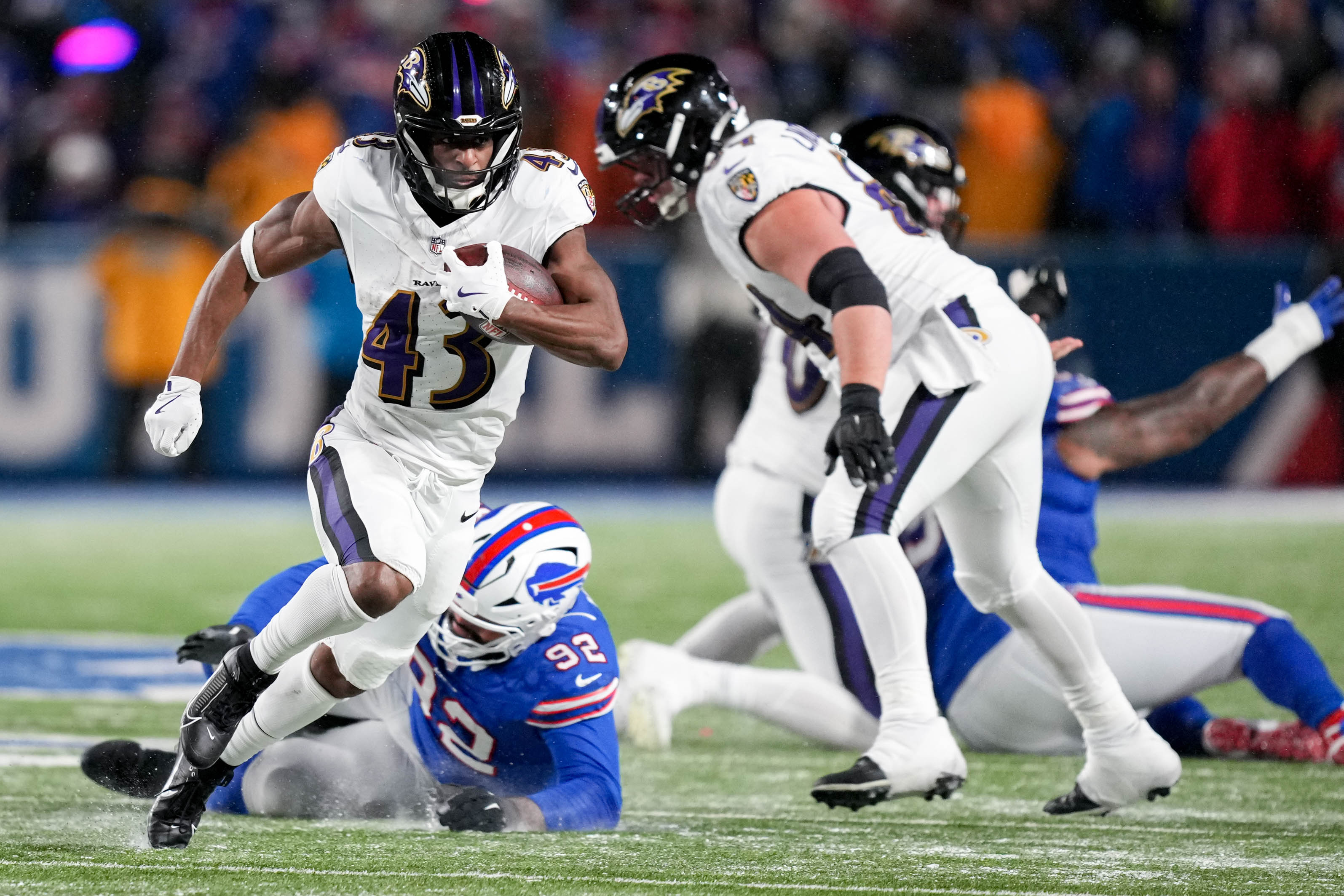 Baltimore Ravens running back Justice Hill (43) sheds a tackle as he rushes forward against the Buffalo Bills defense in a divisional round playoff game at Highmark Stadium in Orchard Park, NY. on Sunday, January 19, 2025.