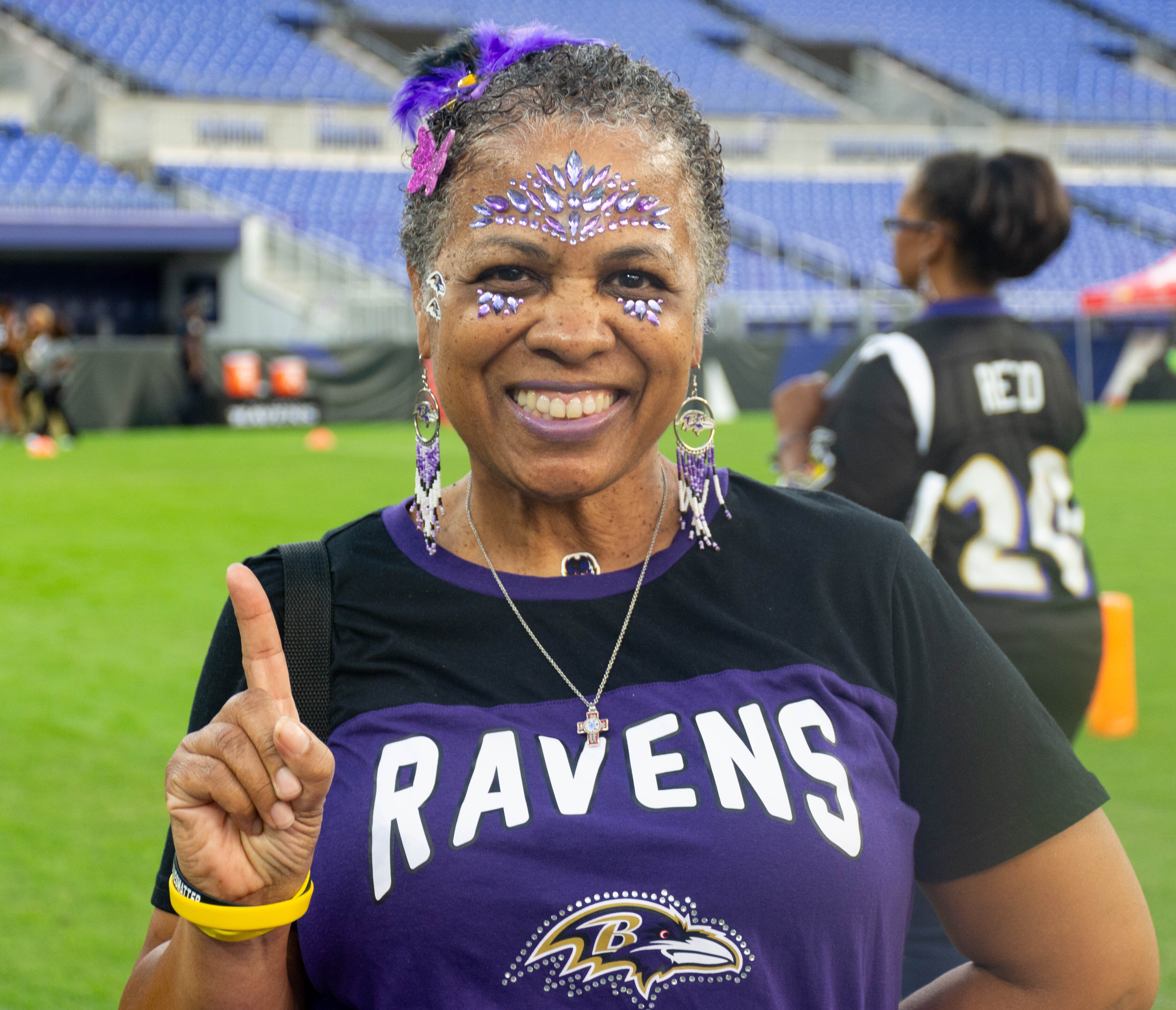 Jill Wood poses on the field of M&T Bank Stadium for the Ravens' "Purple Evening" event on Monday, Oct. 2, 2023. She's attended the event for about 15 years.