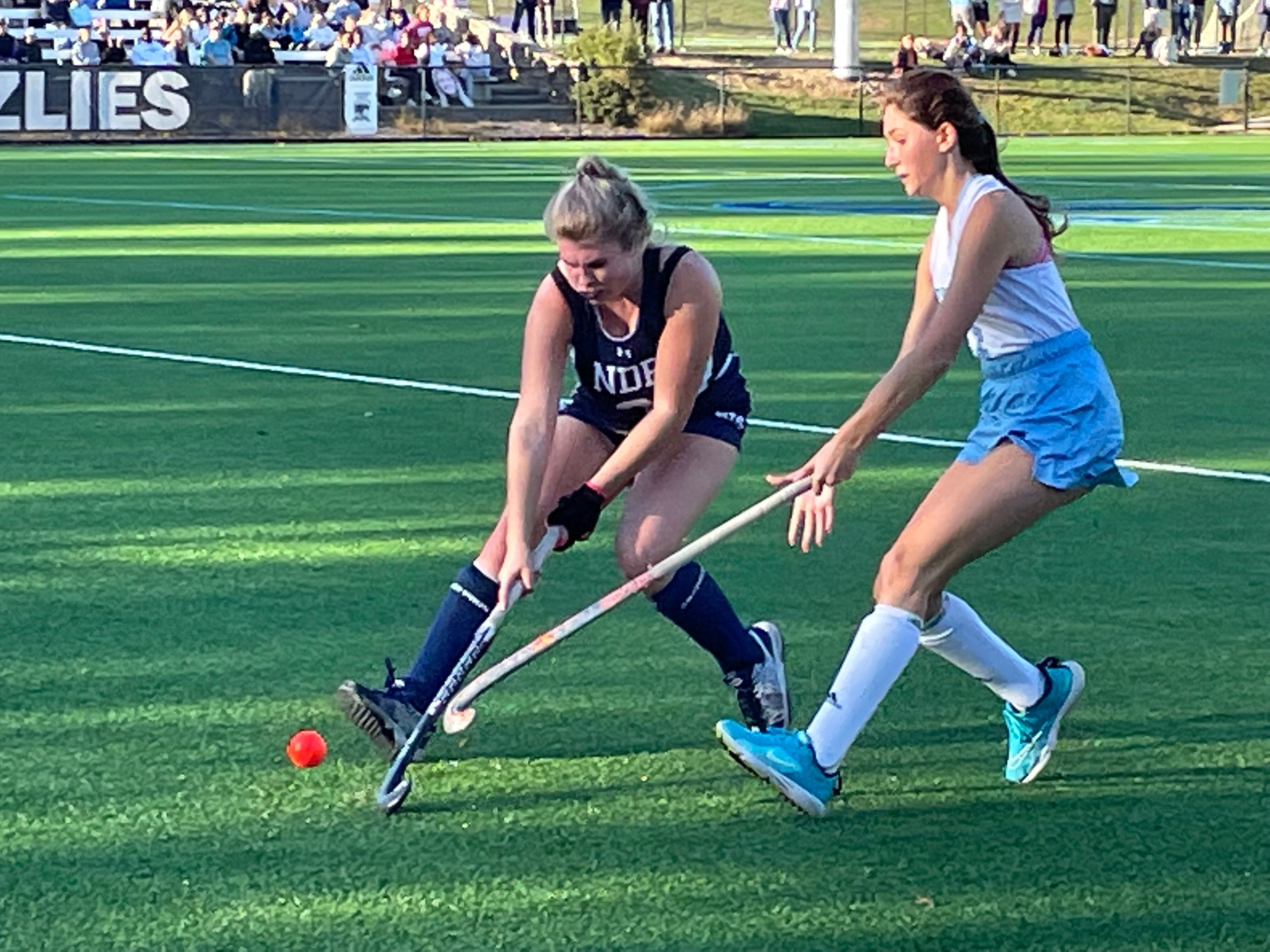 Notre Dame Prep’s Kaitlyn Cody (left) battles for the ball with Garrison Forest’s Bell Mazza in Thursday’s IAAM A Conference field hockey semifinal. With a 9-1 victory, the Grizzlies advance to Sunday’s title rematch with defending champ Archbishop Spalding. The Grizzlies are aiming for their seventh title and their first since 2019.