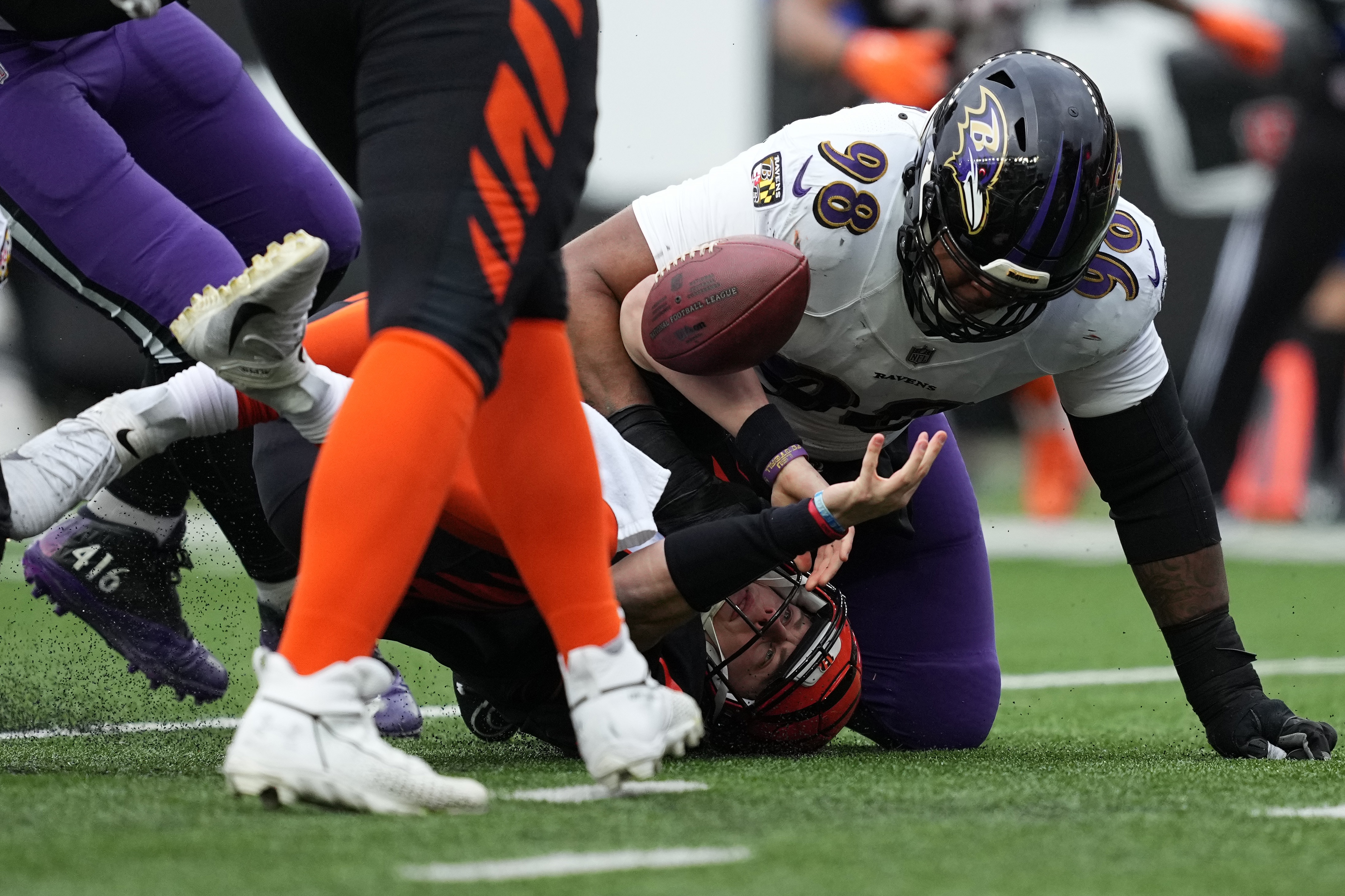 CINCINNATI, OHIO - JANUARY 08: Joe Burrow #9 of the Cincinnati Bengals attempts to recover a fumble against Travis Jones #98 of the Baltimore Ravens during the third quarter at Paycor Stadium on January 08, 2023 in Cincinnati, Ohio.
