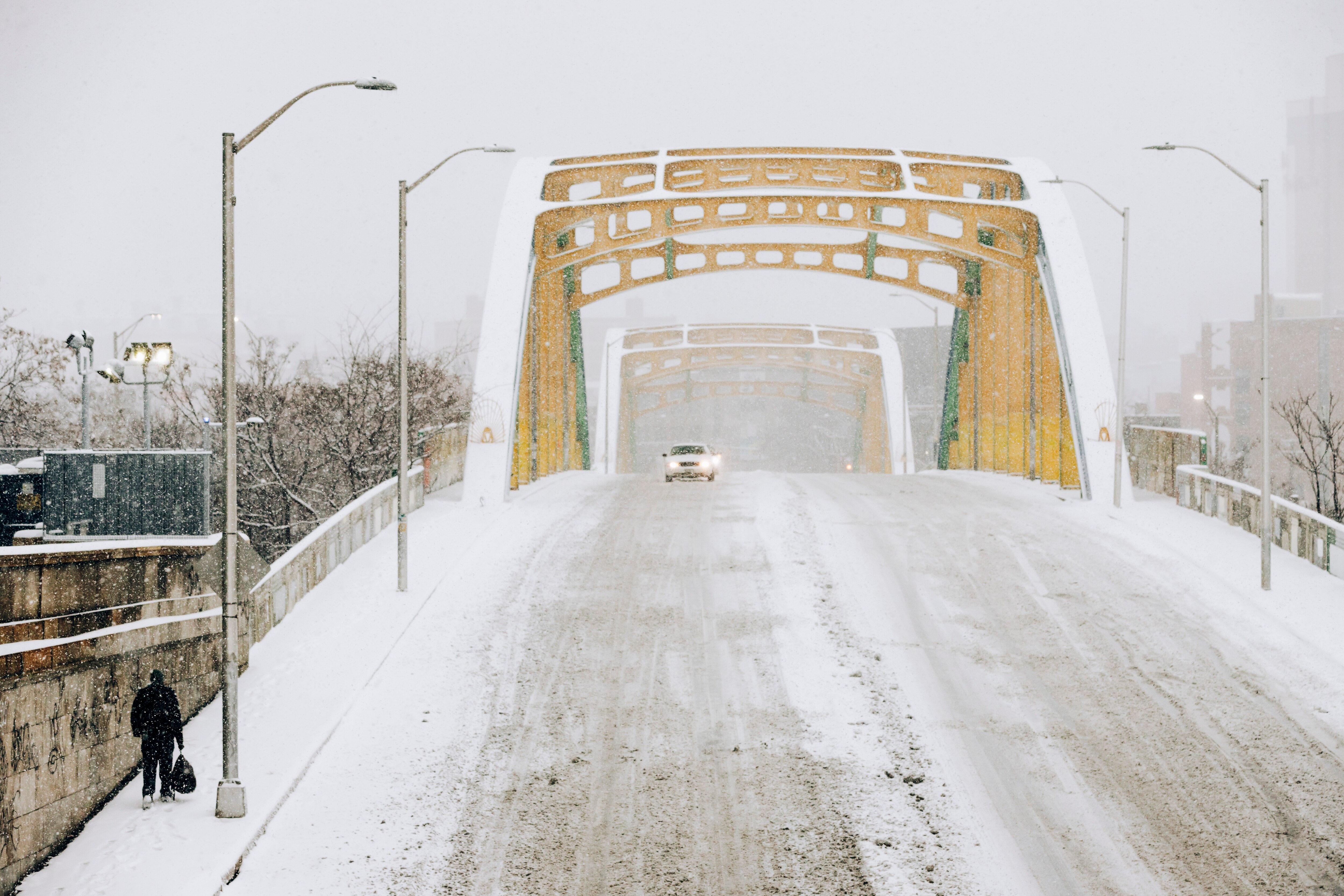 A pedestrian walks towards the Howard Street Bridge on the morning of the winter’s first lasting snowfall, in Baltimore, MD on Monday, Jan. 6, 2025.