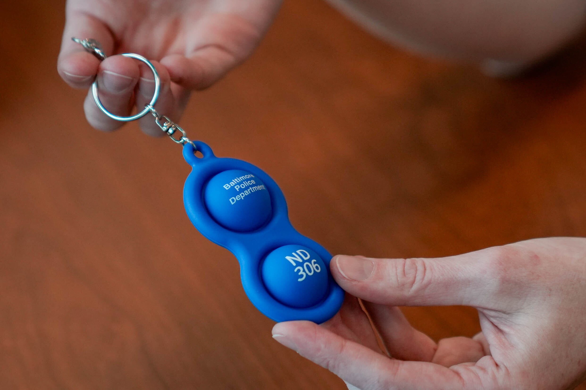 Baltimore Police liaison Deanna Bracken demonstrates an informational key chain used in the Neurodivergent Individuals Database program.