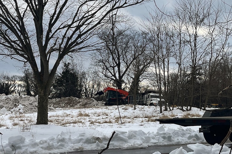 Trucks shuffle in and out of a site off of Old Frederick Road and Birchwood Drive in the Uplands neighborhood.