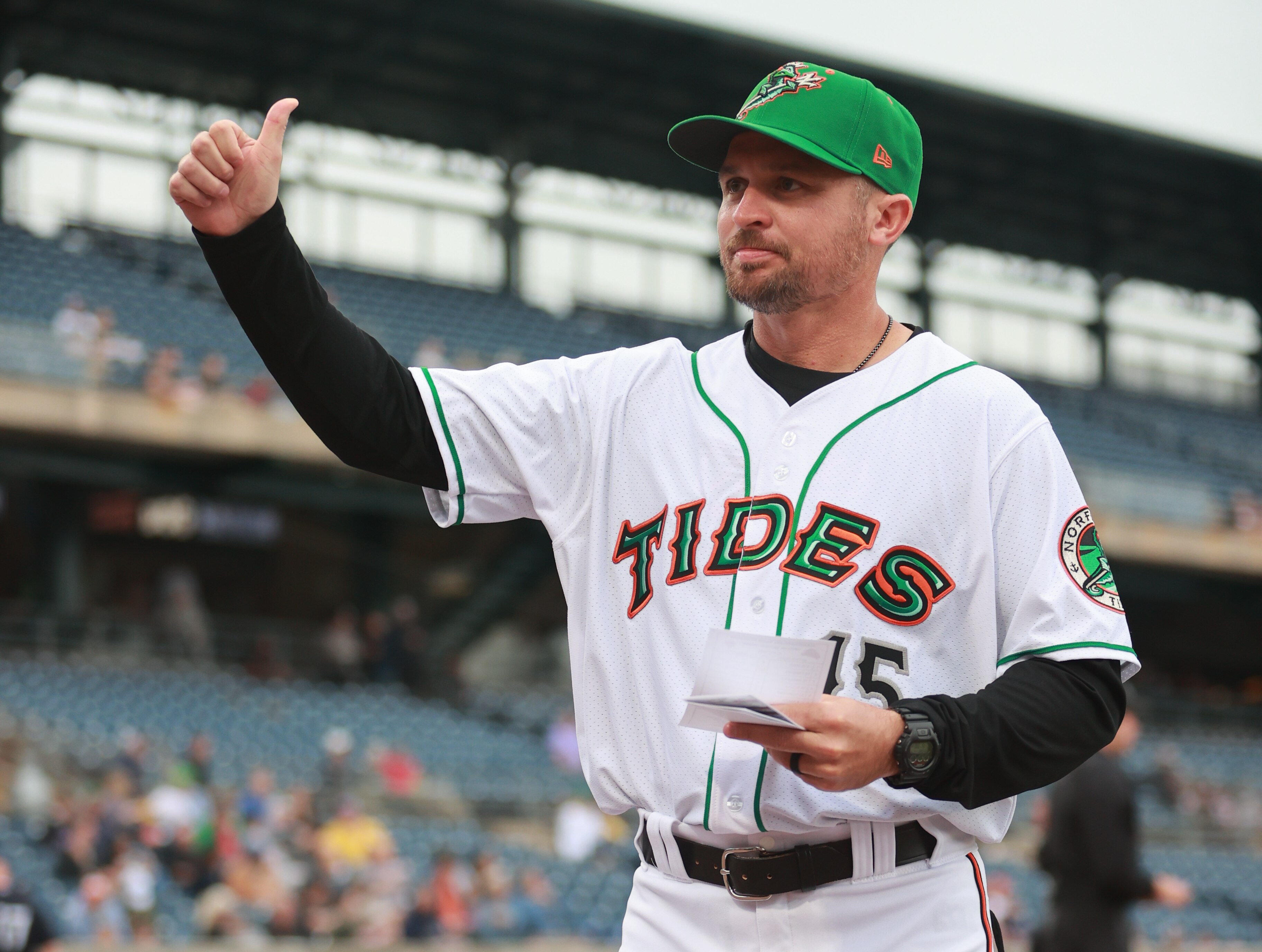 Norfolk Tides manager Buck Britton gives a thumbs-up before a game. As manager of a talented Triple-A team, Britton often gets to tell players they're going to the majors.