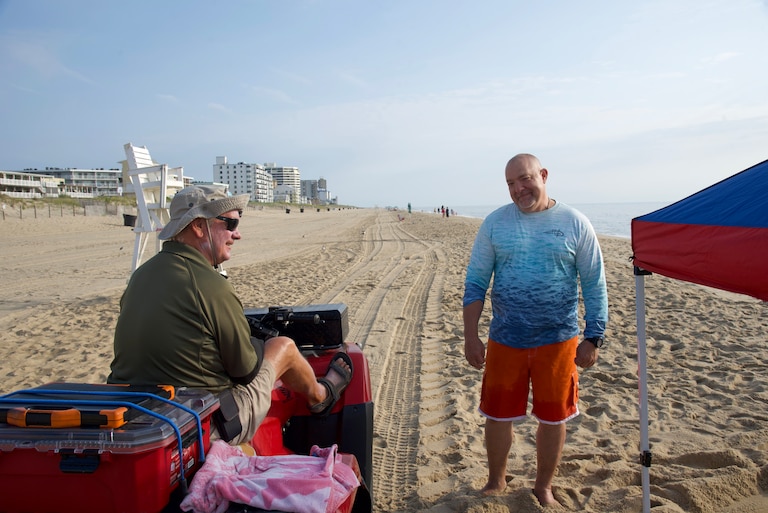 Ocean City code enforcer Tim Miller speaks with tourist Vince Springer about his unattended canopy Aug. 16