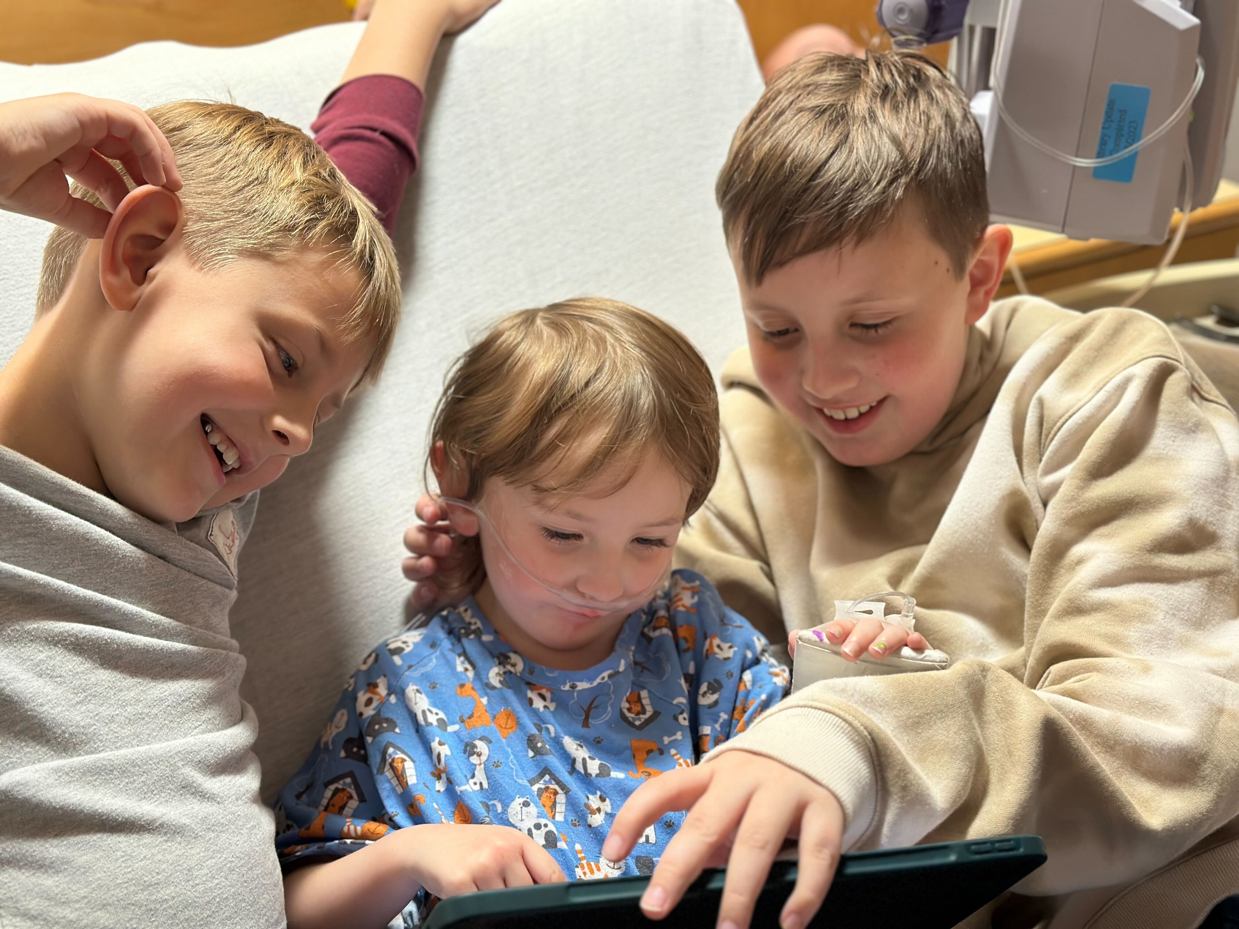 Alma Geddes, 3, enjoys a visit from her older brothers while hospitalized with pneumonia at GBMC.