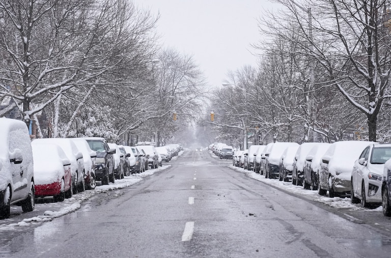 The mostly empty road with snow-covered cars on Calvert St. on a snowy day in Baltimore on January 19, 2024.