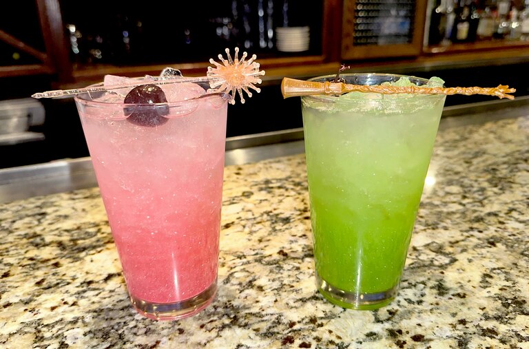 Bonefish Grill in Gaithersburg serves swankified martinis—pictured here in mocktail form, which the restaurant calls the OzNOpolitan and Emerald City Cooler, from left to right—with matching Glinda and Elphaba prop garnishes.