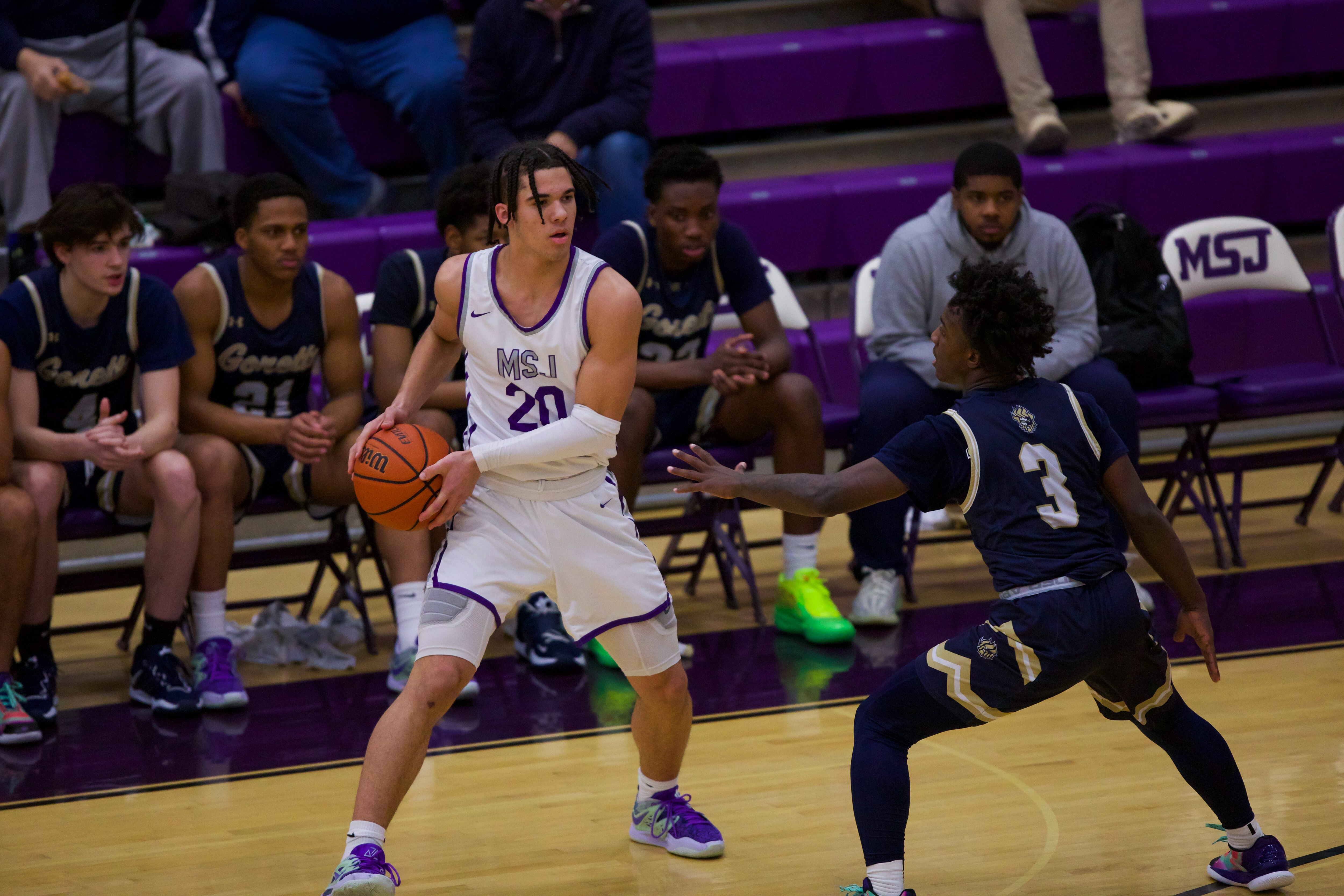 Player No. 3 Jahsan Johnson guards No. 20 Austin Abrams at the Mount St. Joseph High School basketball game against St. Maria Goretti High School for first place in the Baltimore Catholic League on February 15, 2023.
