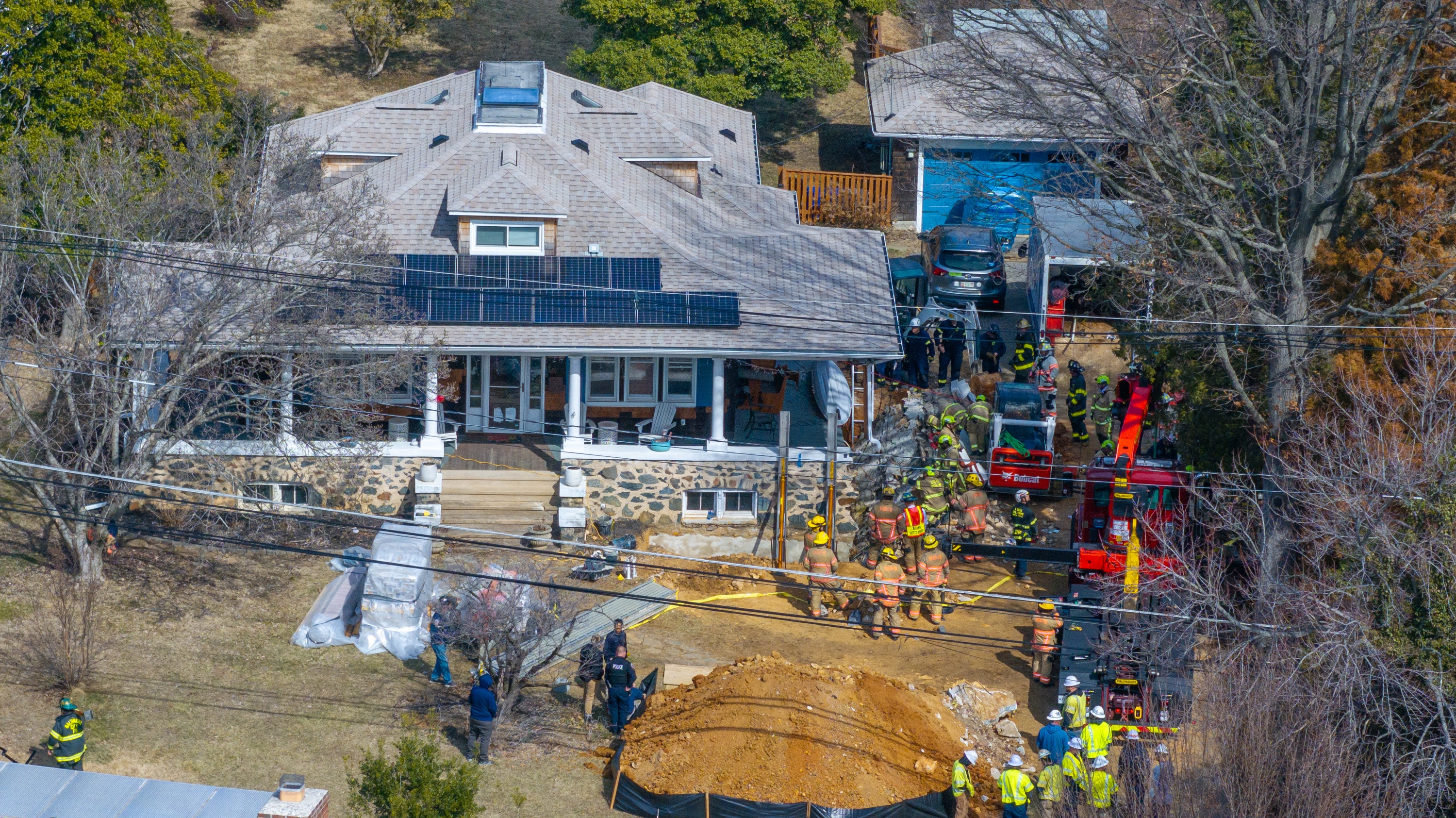 First responders attempt to rescue trapped construction workers on Academy Road in Catonsville on Friday.