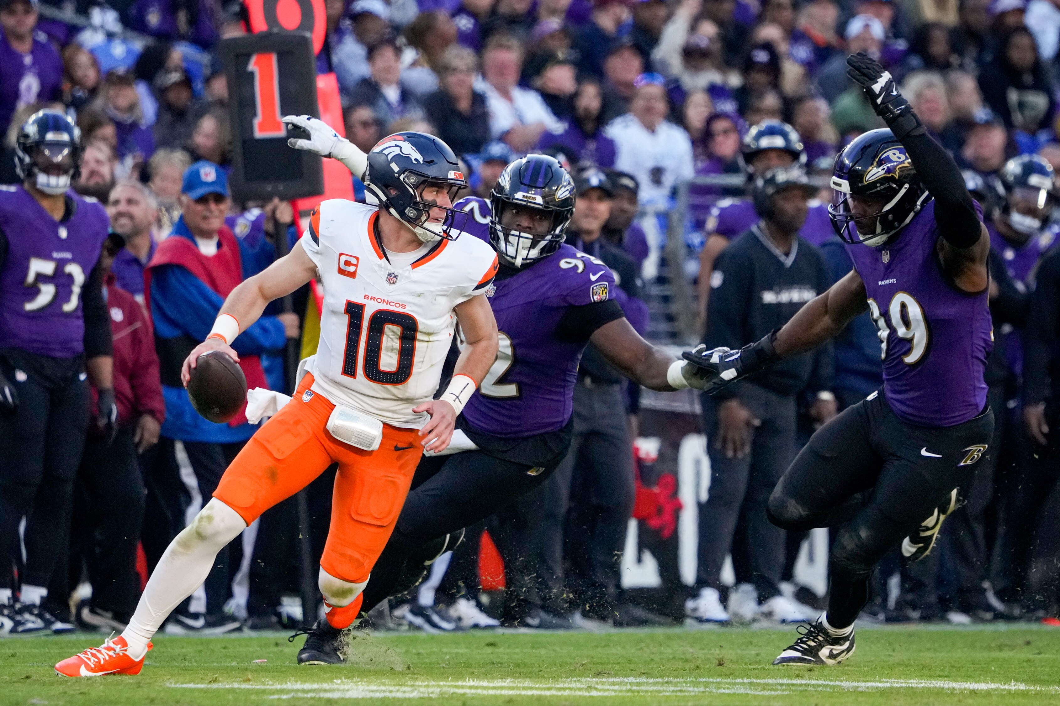 Baltimore Ravens defensive tackle Nnamdi Madubuike (92) and linebacker Odafe Oweh (99) chase down Denver Broncos quarterback Bo Nix (10) in a regular season game at M&T Bank Stadium on Sunday, November 3, 2024.