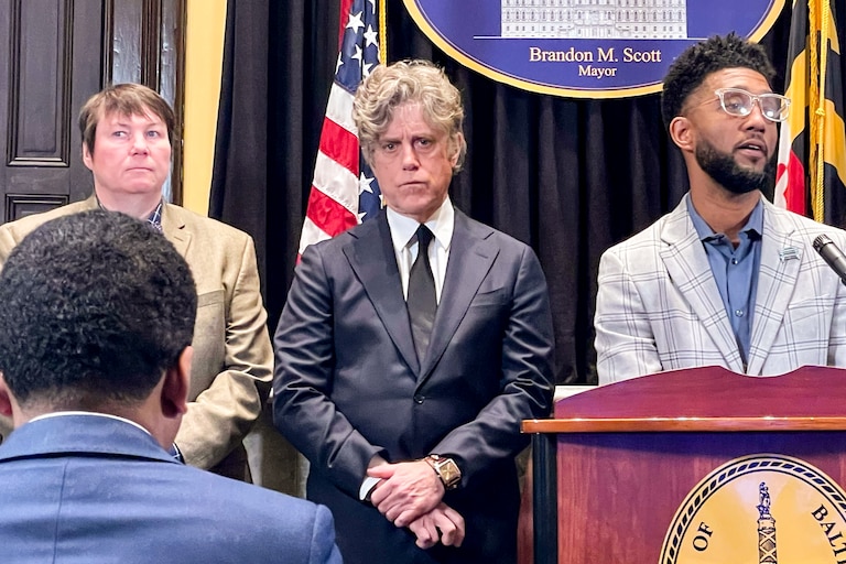 Mayor Brandon Scott introduces his nominee for housing commissioner, Tim Keane (center). Housing Commissioner Alice Kennedy stands at left.