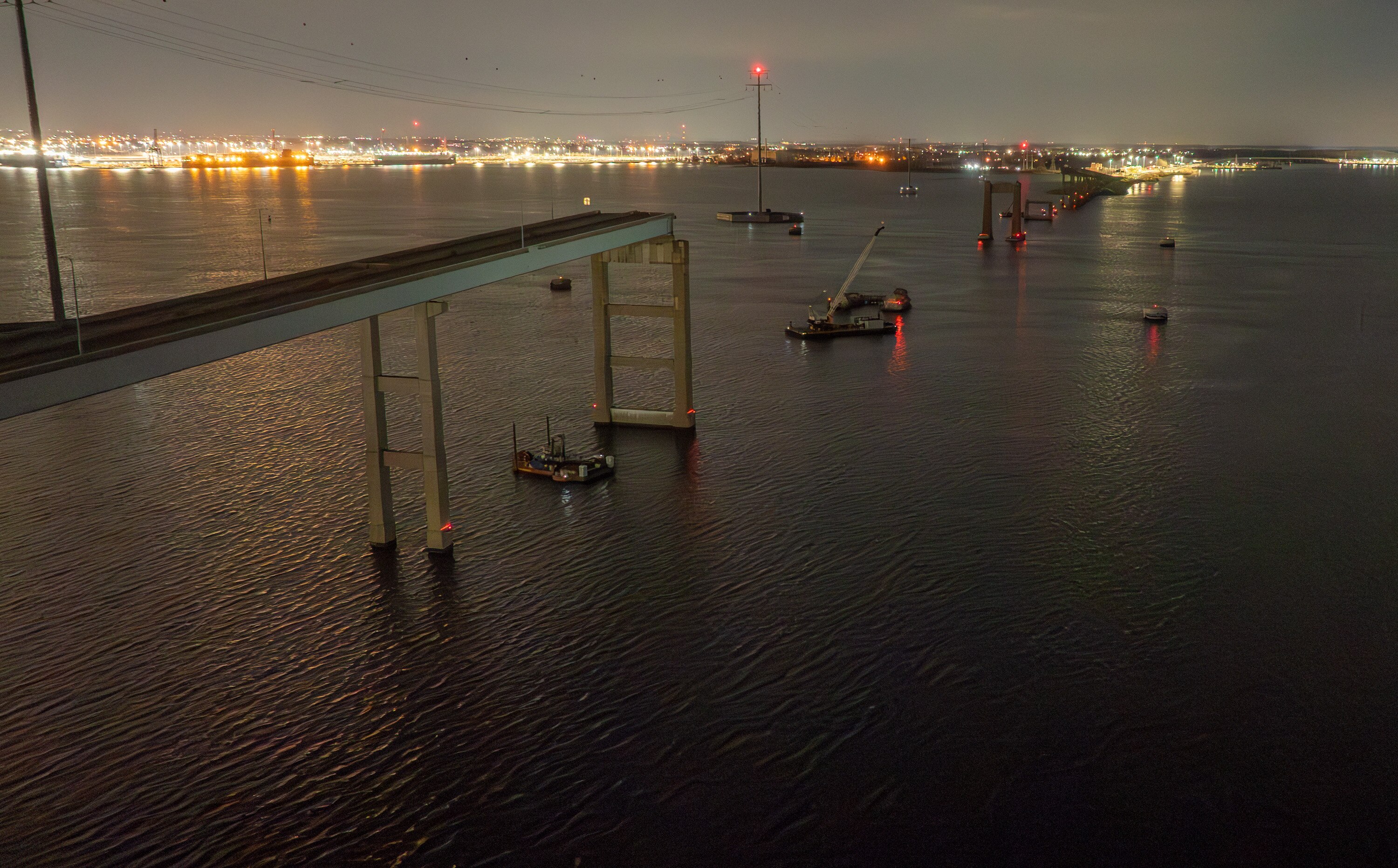 The remains of the Francis Scott Key Bridge are seen before dawn on the one year anniversary of the collapse of the bridge after being hit by the container ship Dali.