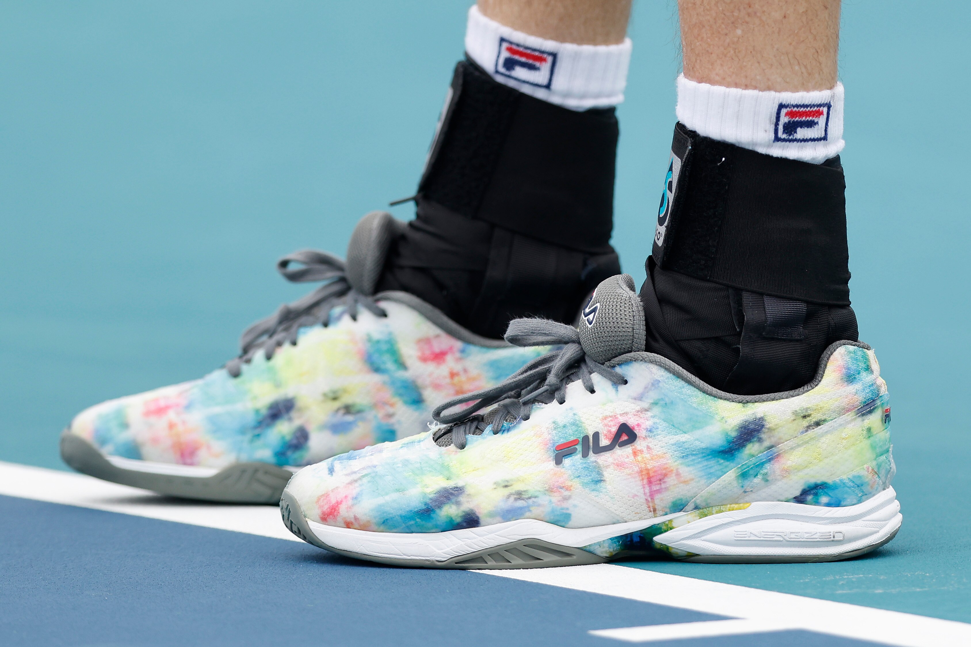 MIAMI GARDENS, FLORIDA - MARCH 30: A detail of John Isner of the United States Fila shoes against Roberto Bautista Agut of Spain during the Miami Open at Hard Rock Stadium on March 30, 2021 in Miami Gardens, Florida.