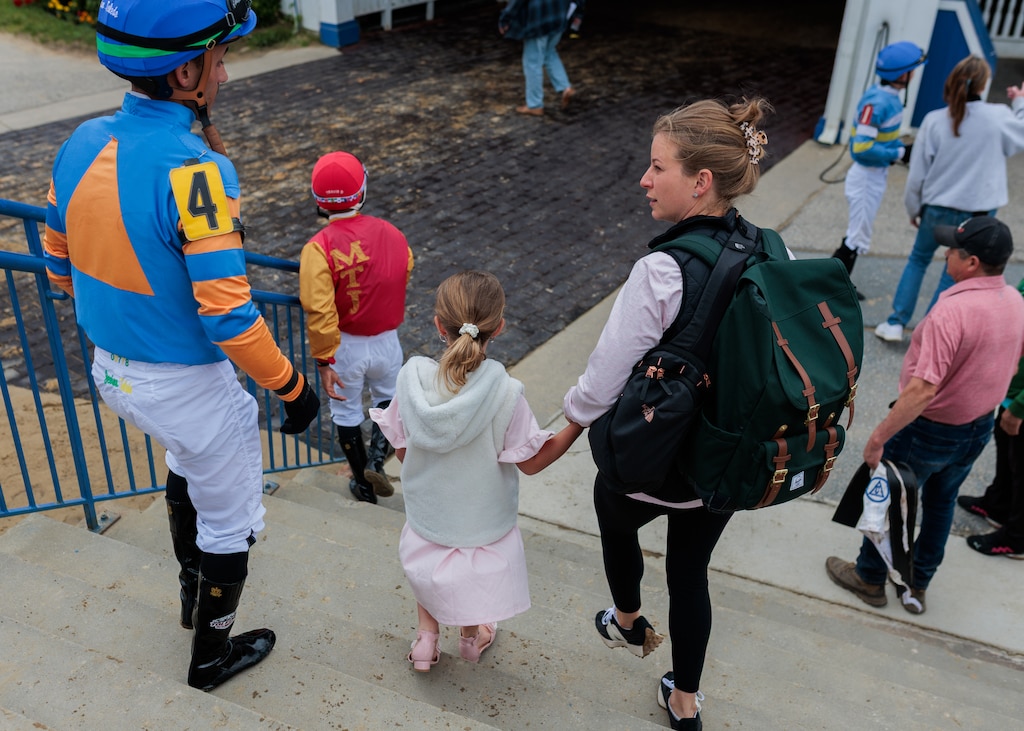 Horse trainer Brittany Russell holds her daughter’s hand while she chats with jockey Jevian Toledo after The Kelso Turf race at Laurel Park racetrack. Toledo rode Haulin Oats, a horse she trains.