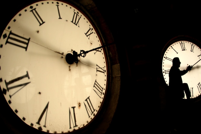 FILE - Custodian Ray Keen inspects a clock face before changing the time on the 100-year-old clock atop the Clay County Courthouse March 8, 2014, in Clay Center, Kan. (AP Photo/Charlie Riedel, File)