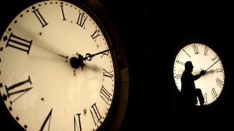 FILE - Custodian Ray Keen inspects a clock face before changing the time on the 100-year-old clock atop the Clay County Courthouse March 8, 2014, in Clay Center, Kan. (AP Photo/Charlie Riedel, File)