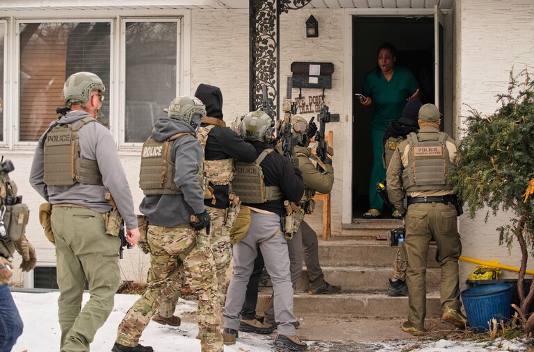 Teyana Gibson Brown, wife of Garrison Gibson, reacts in the doorway of her home after a federal immigration officer used a battering ram to break down a door before arresting Garrison Gibson, Sunday, Jan. 11, 2026, in Minneapolis.